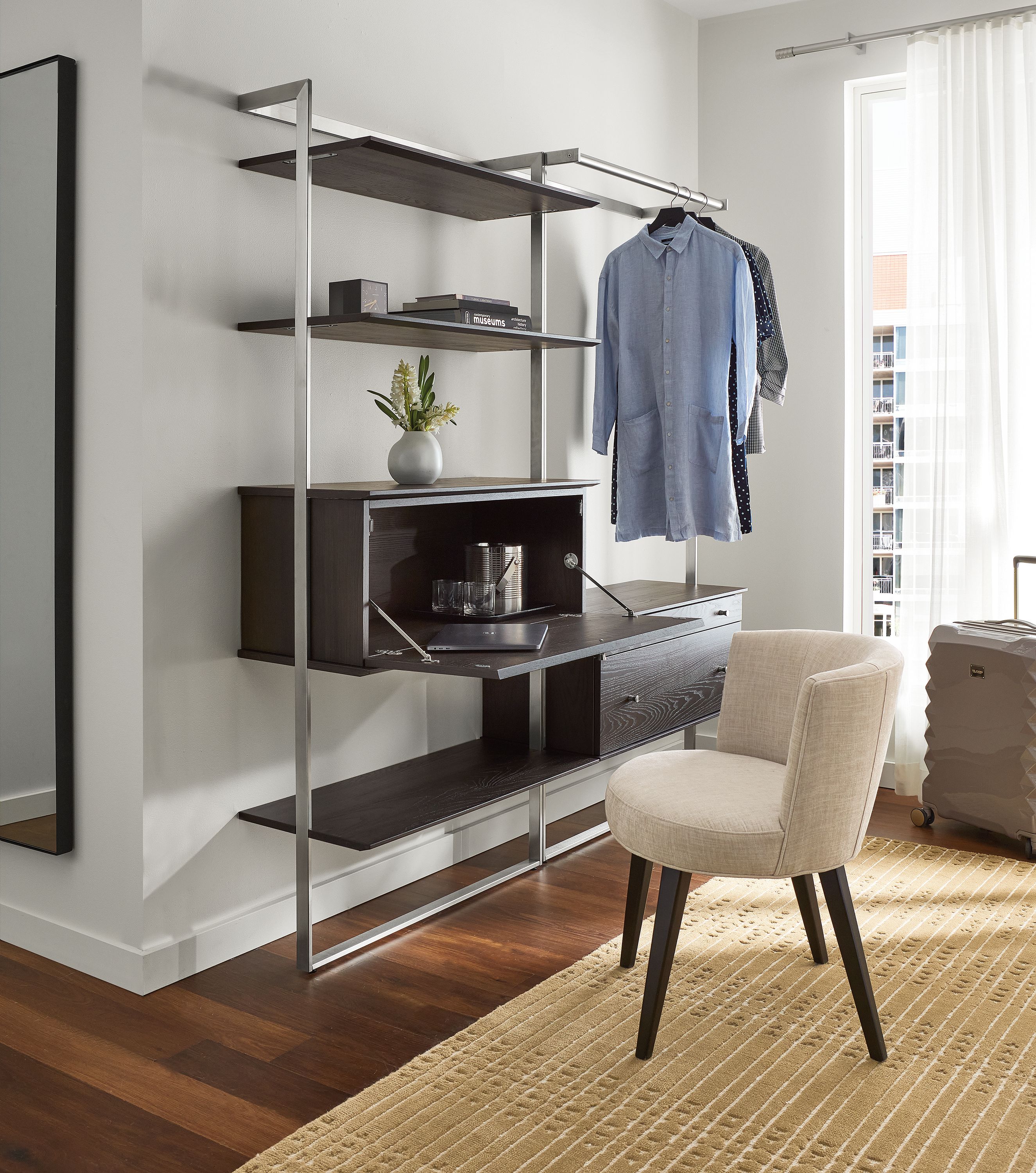 Hotel bedroom with Beam wall unit with clothing bar and dropdown desk in Charcoal and Stainless Steel.