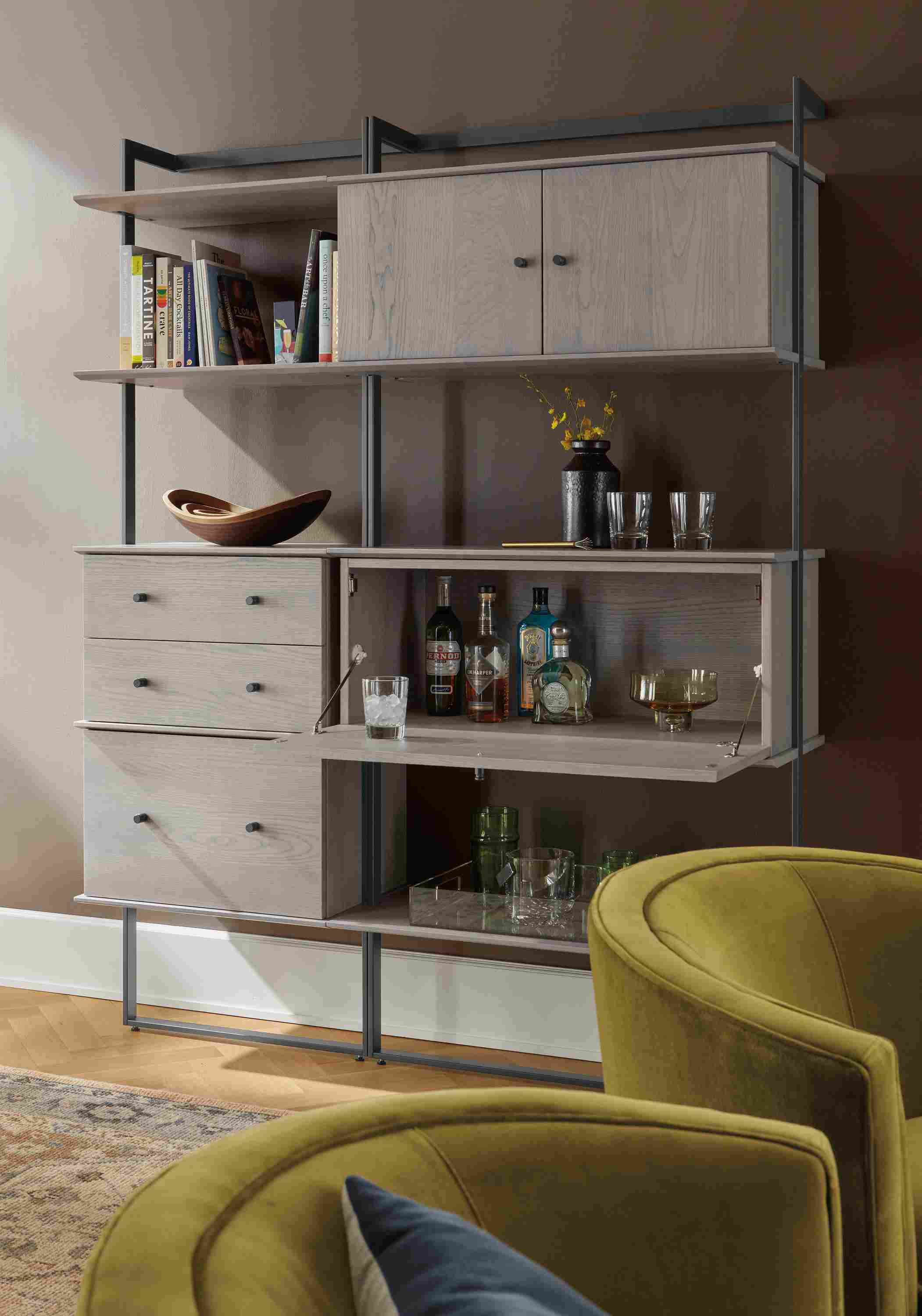 Living room with Beam bookcase wall unit in graphite with shell on ash inserts and 2 Otis swivel chairs in Vance Mustard.