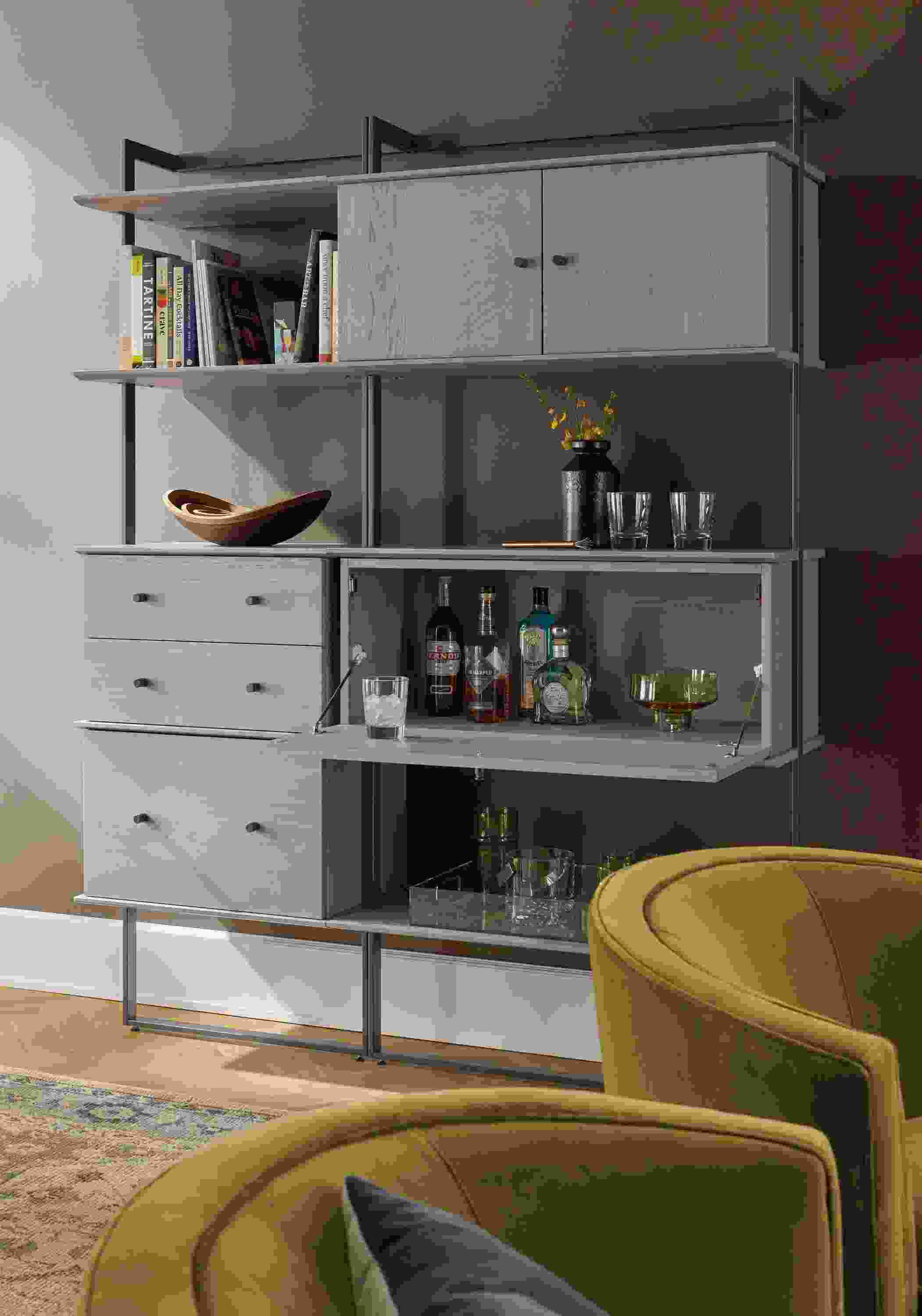 Living room with Beam bookcase wall unit in graphite with shell on ash inserts and 2 Otis swivel chairs in Vance Mustard.
