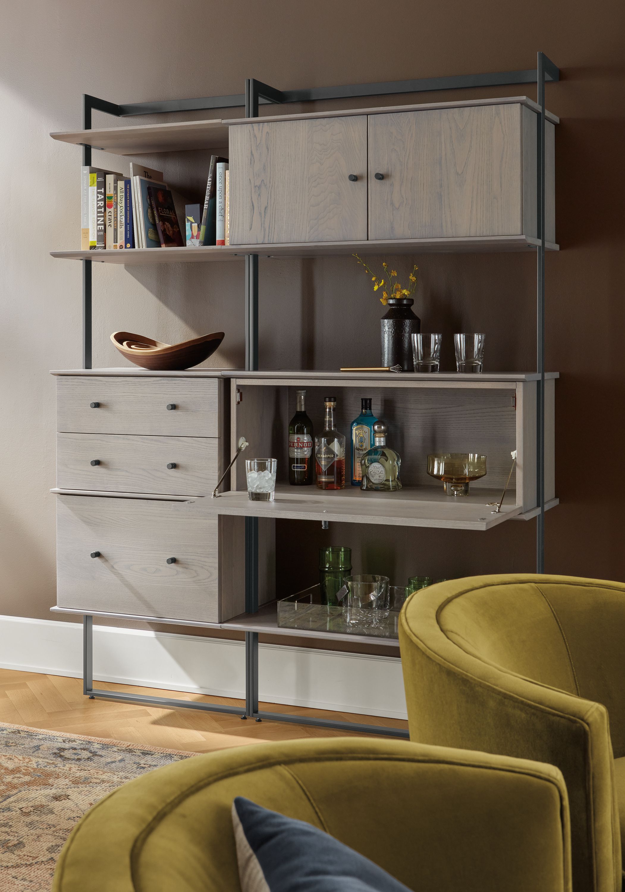 Living room with Beam bookcase wall unit in graphite with shell on ash inserts and 2 Otis swivel chairs in Vance Mustard.