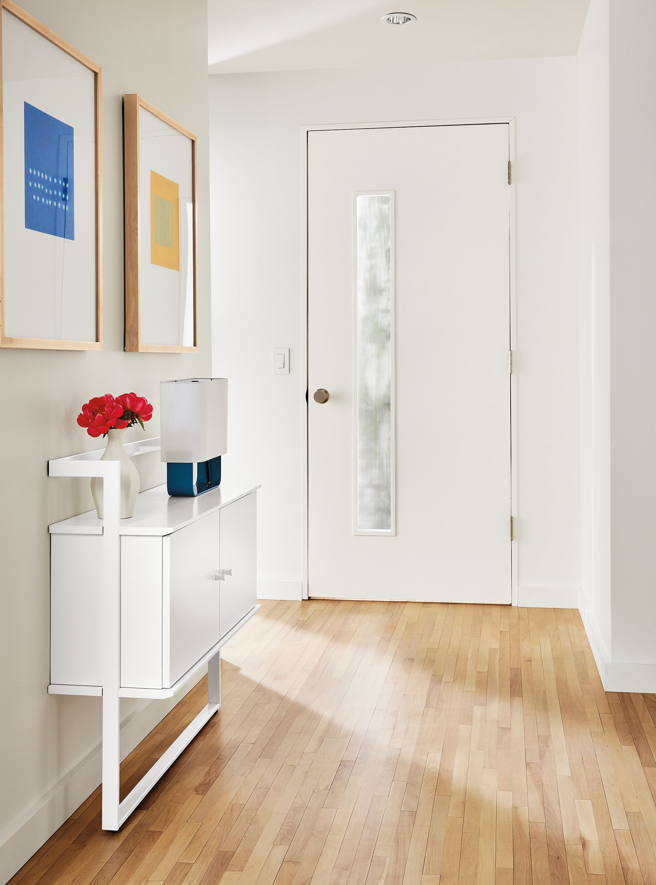 Entryway with small Beam bookcase in white, Juni van dyke wall art, duo lamp.