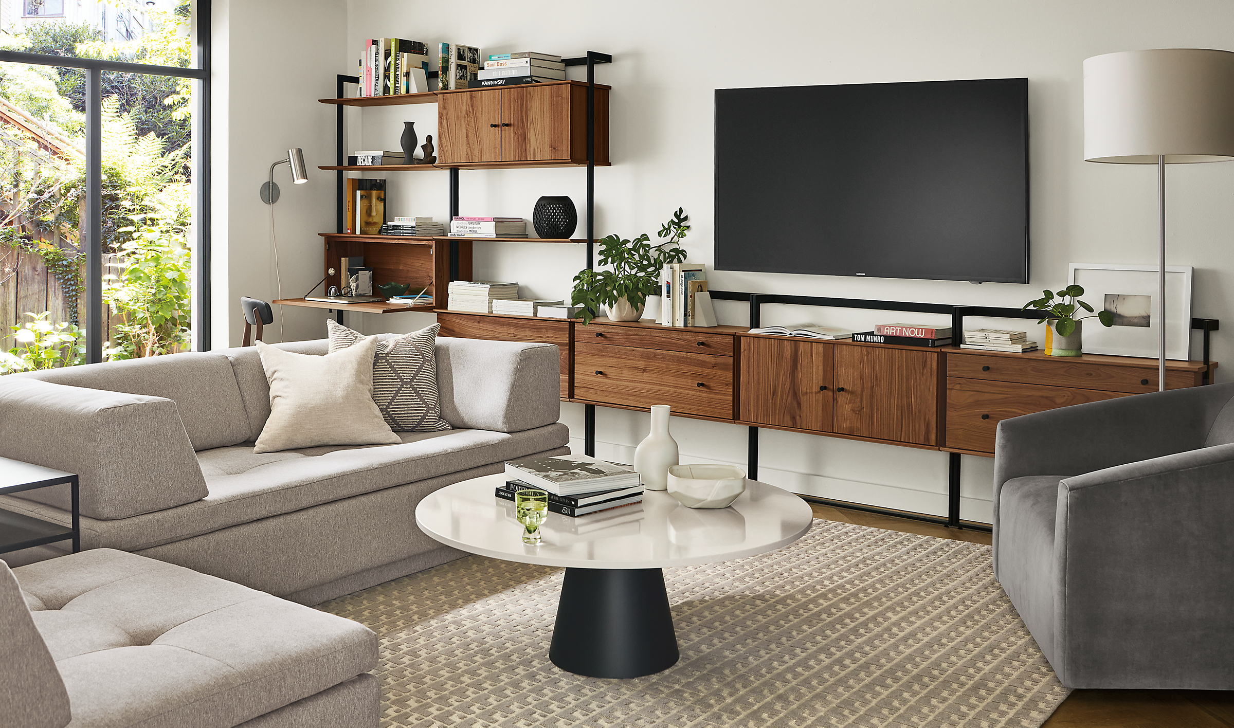 Living room with Beam bookcase media wall unit, Miranda sectional, Decker coffee table.