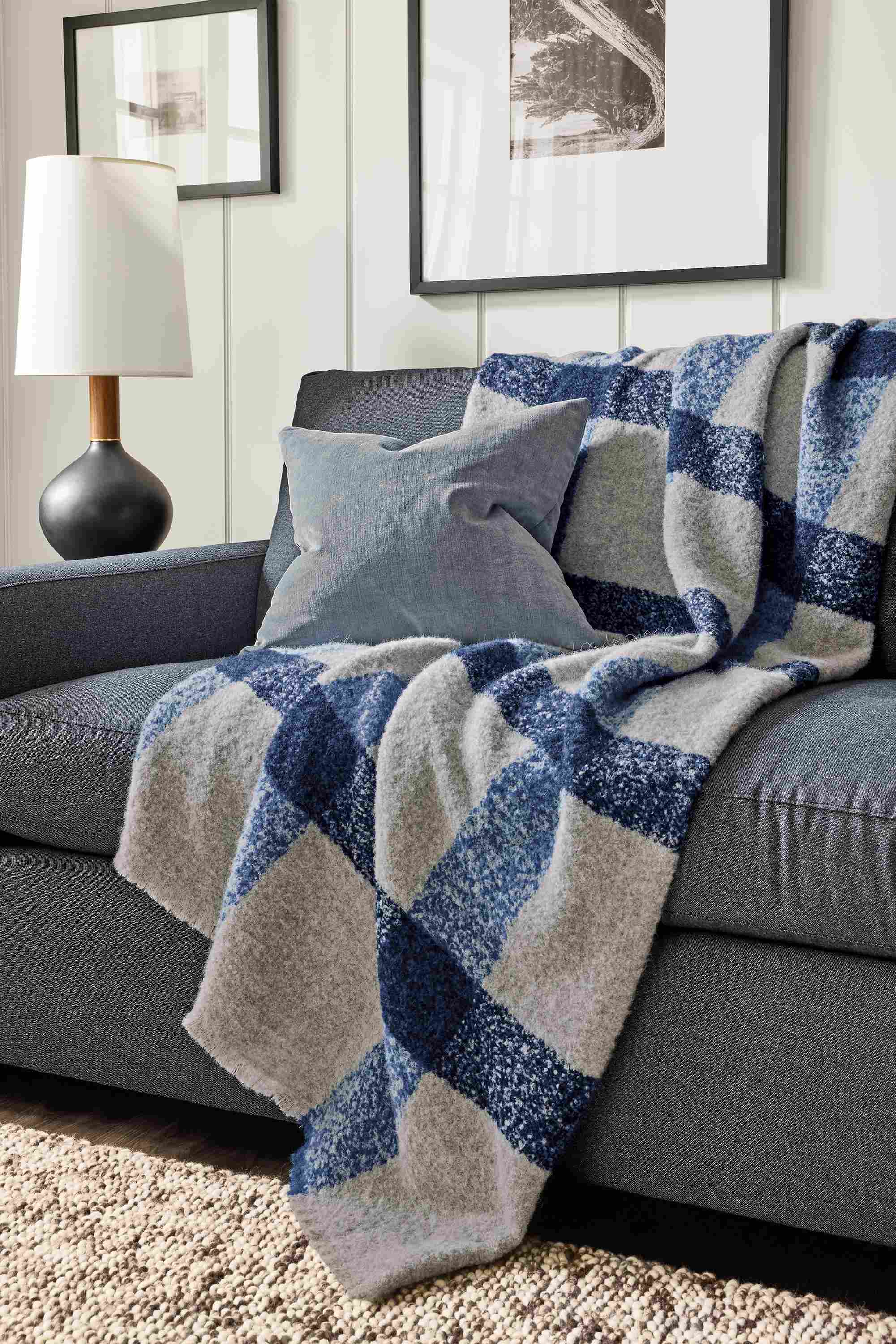 Living room with Beaumont throw blanket in ink on a Ryan 106-wide, two-cushion sofa in Myers Navy.