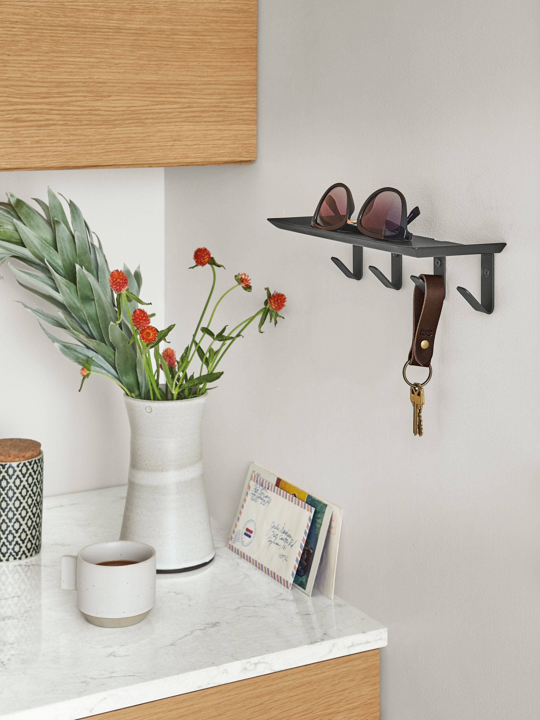 Detail of Bend wall shelf with hooks in Graphite in kitchen/entryway.