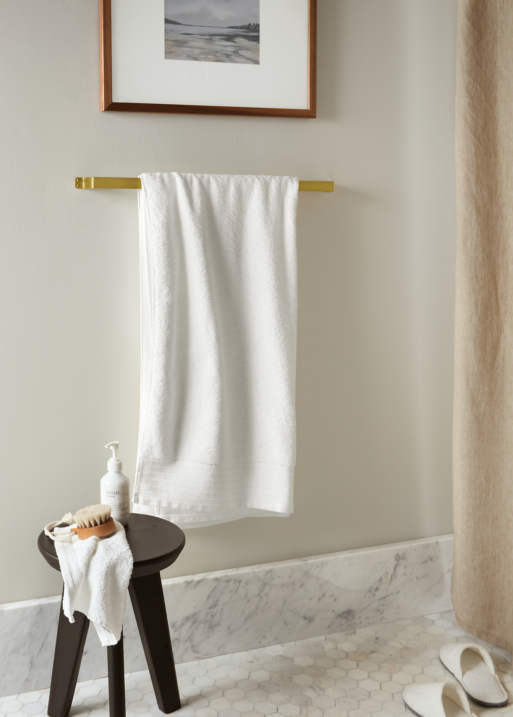 bend towel rack in gold holding fendwick towel in white