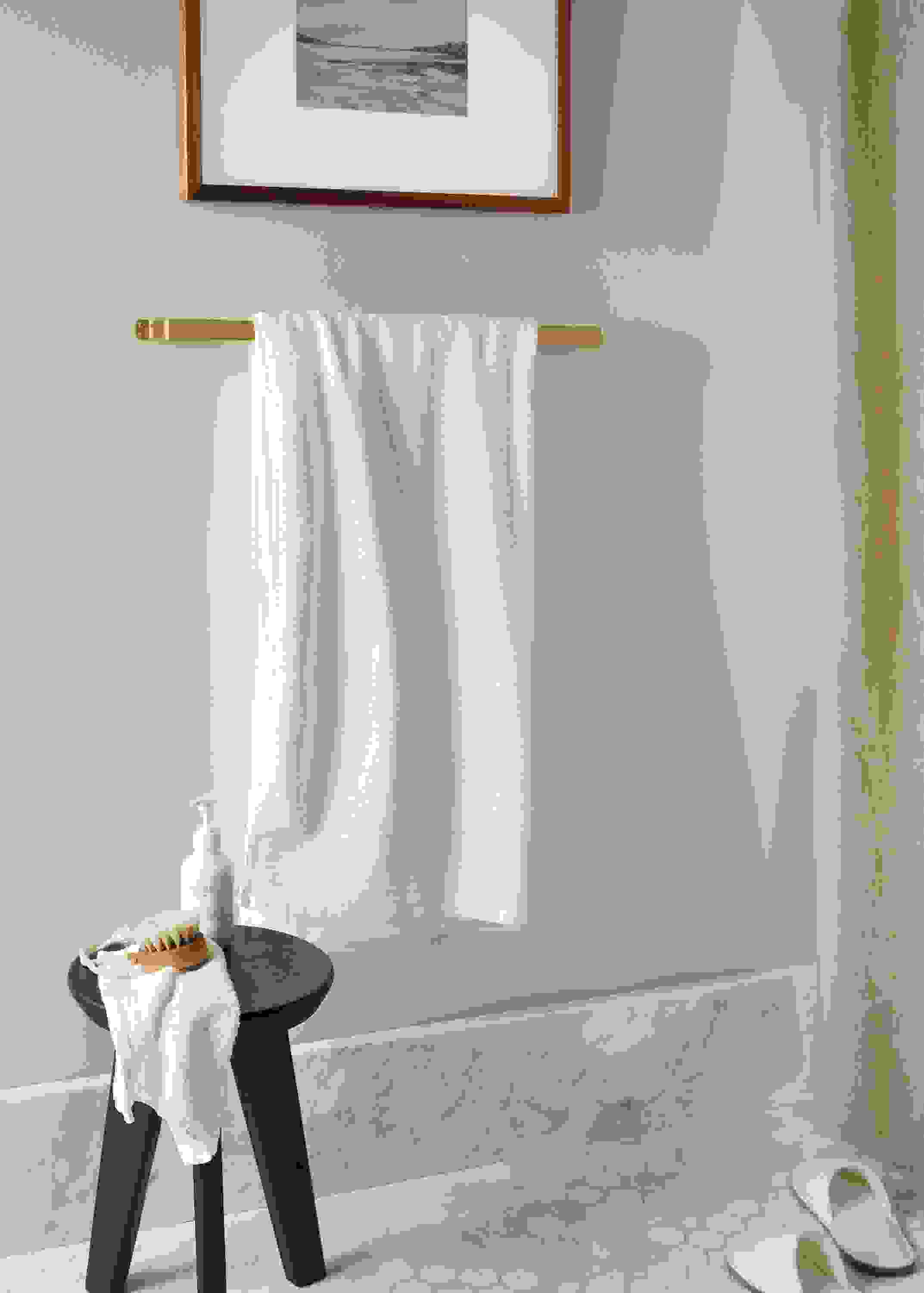 bend towel rack in gold holding fendwick towel in white