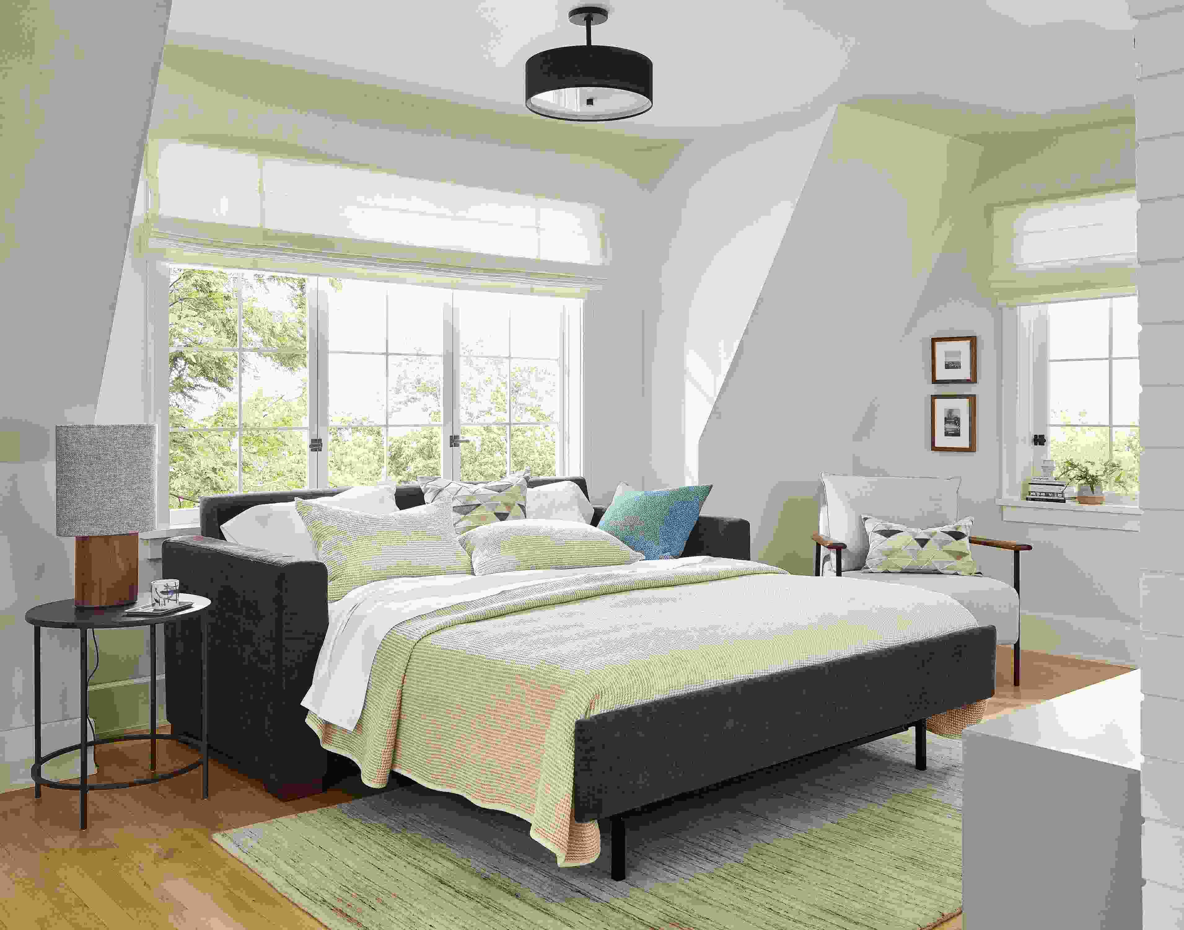 Bedroom showing Berin queen sleeper sofa in Mori Charcoal open and Nomad rug in ivory/grey.
