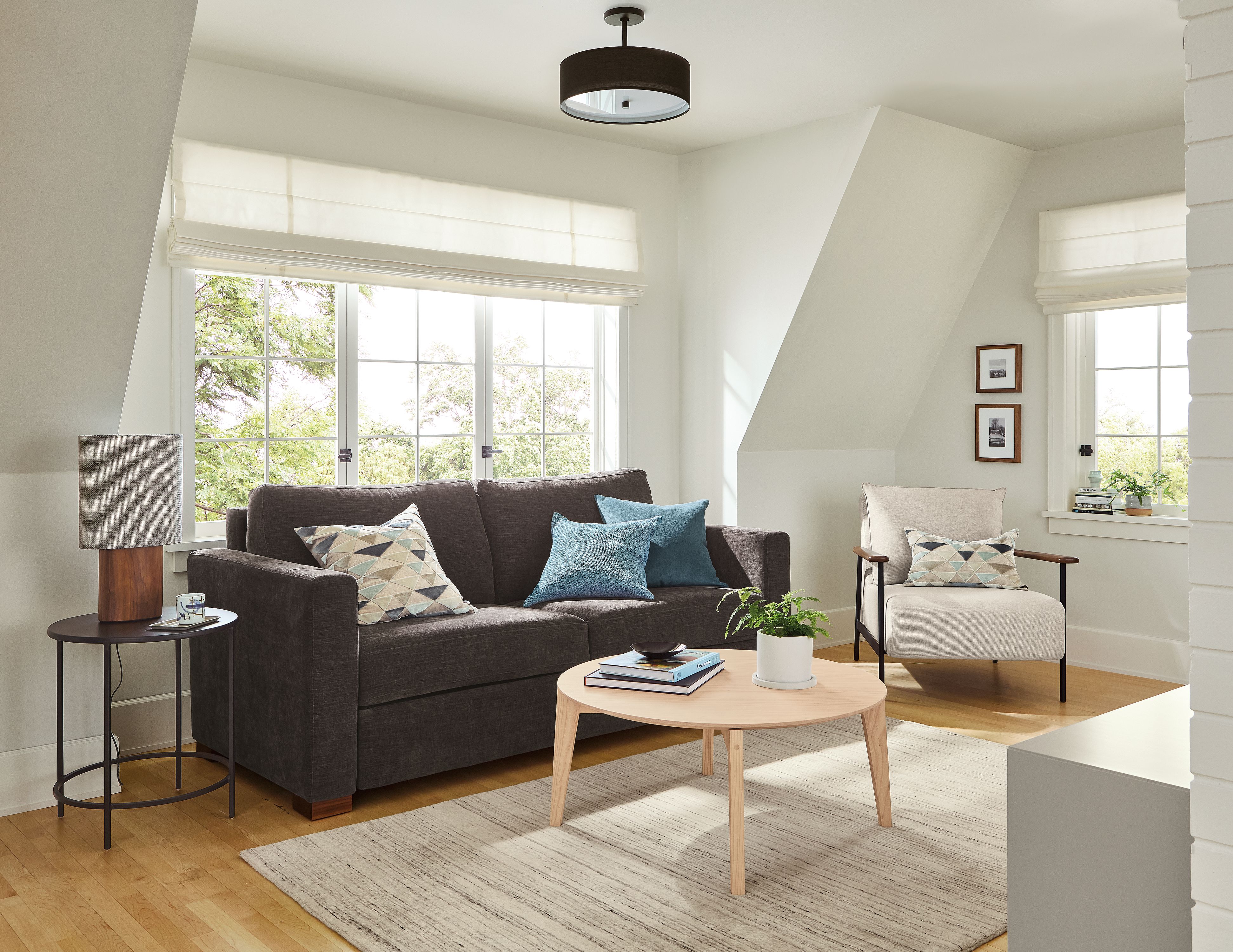 Living room with Berin queen sleeper sofa in Mori Charcoal, Xavier chair in Gino Oatmeal and Orlin Table.