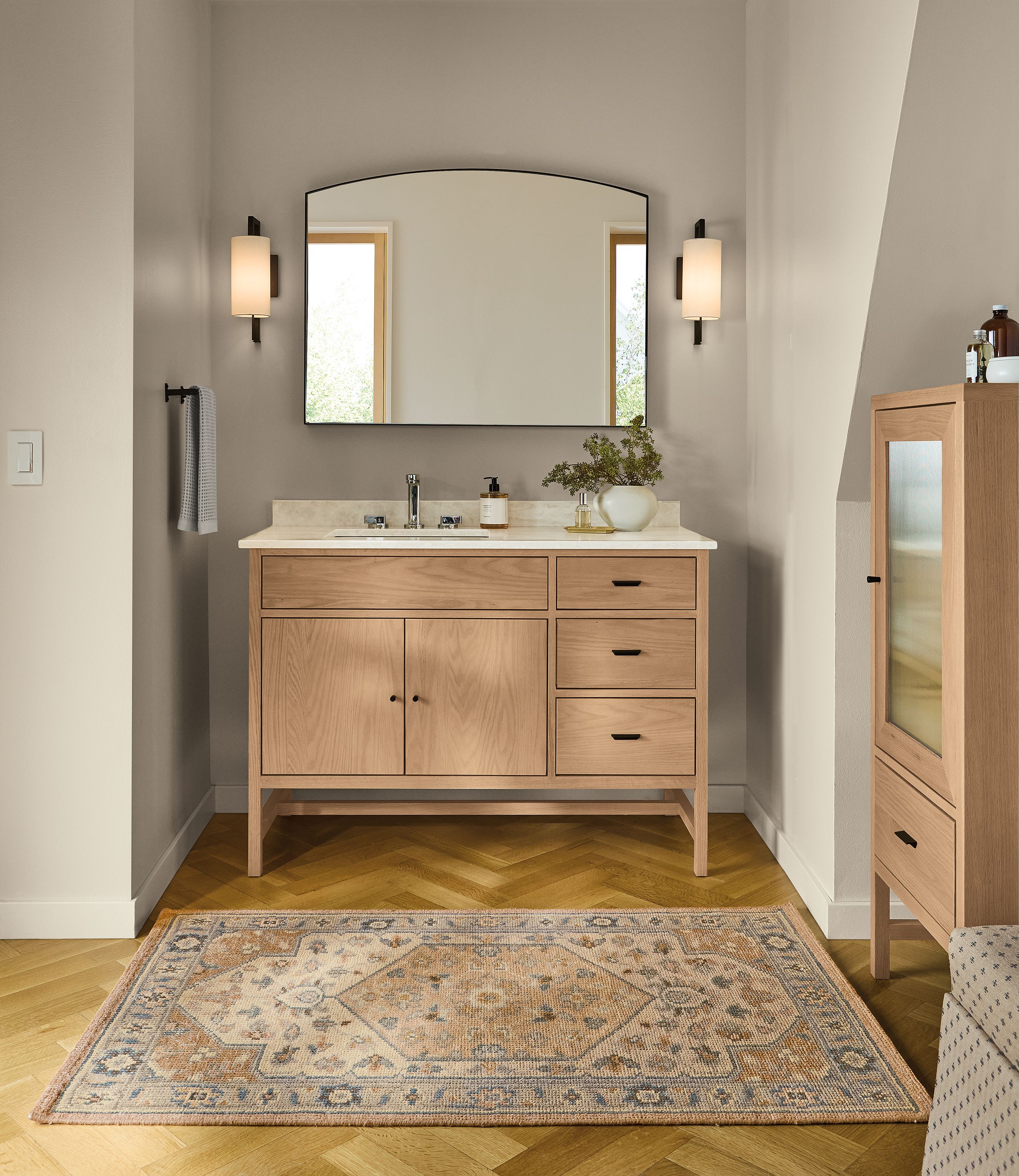 Bathroom with Berkeley 48-wide single-sink vanity in rye on red oak with Mahal Quartz top and Infinity arched mirror in graphite.