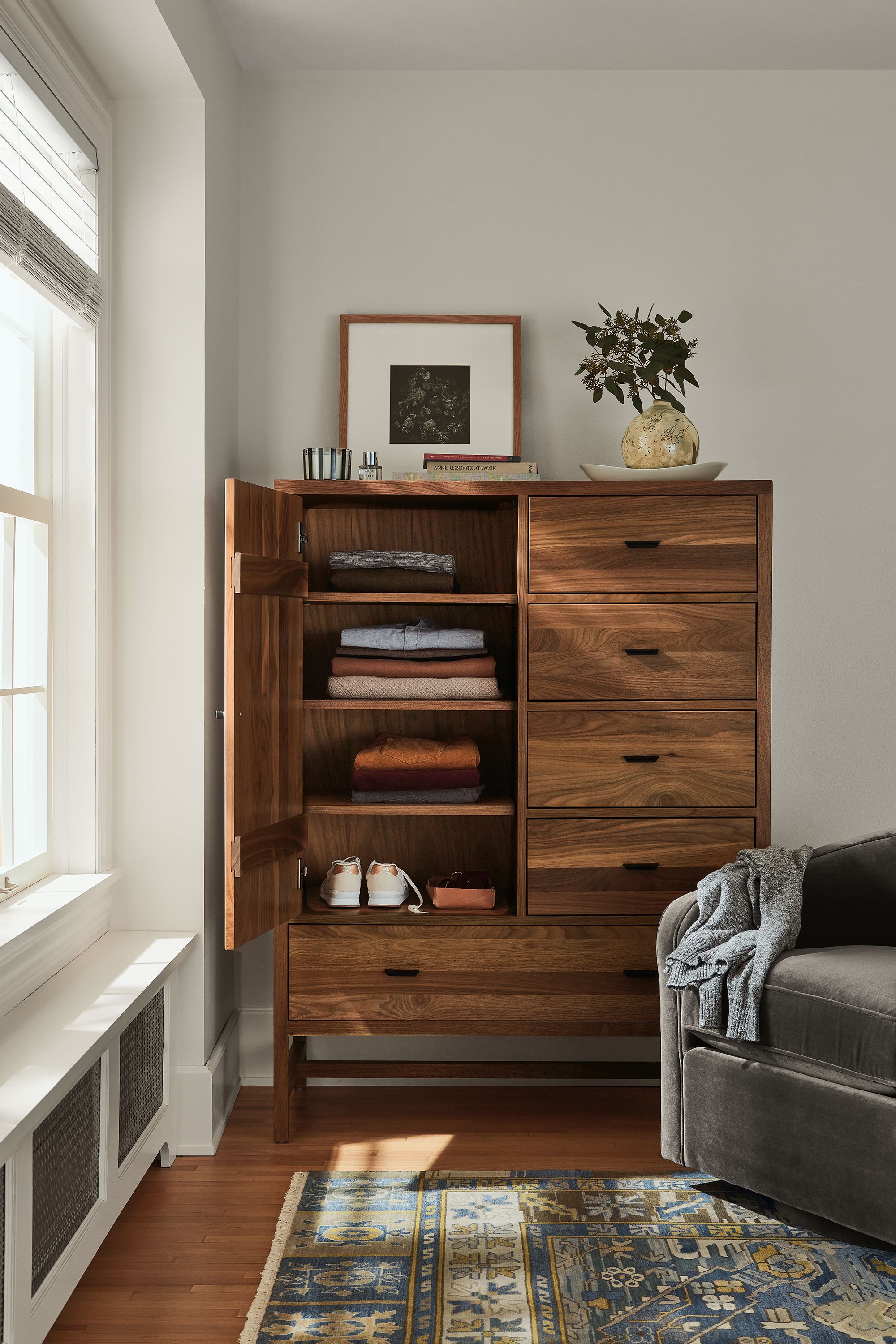 detail of berkeley storage cabinet in walnut with door open in bedroom.