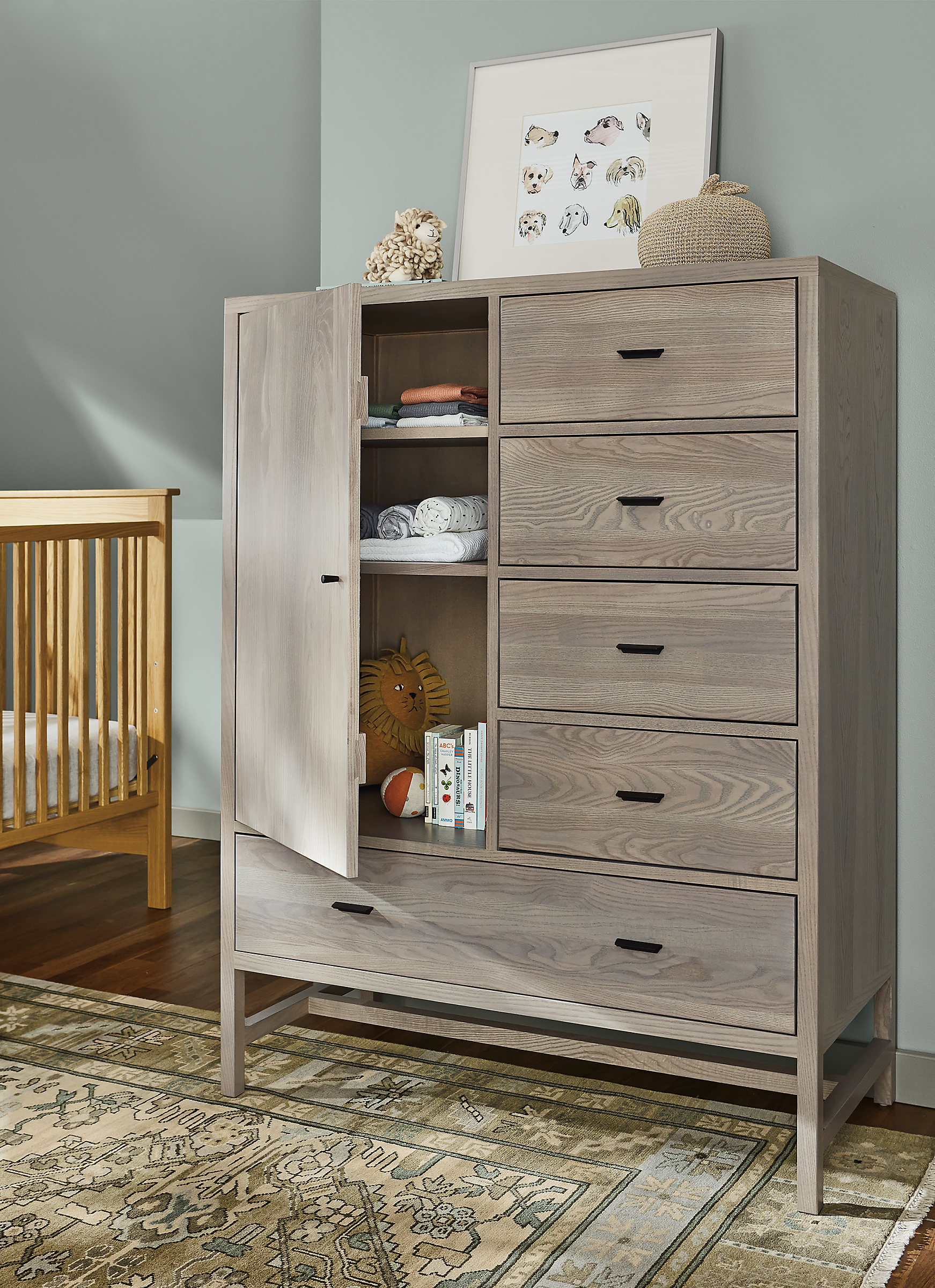 Nursery with Berkeley 42-wide 56-high storage cabinet in shell with open door and Kayseri rug in Moss.