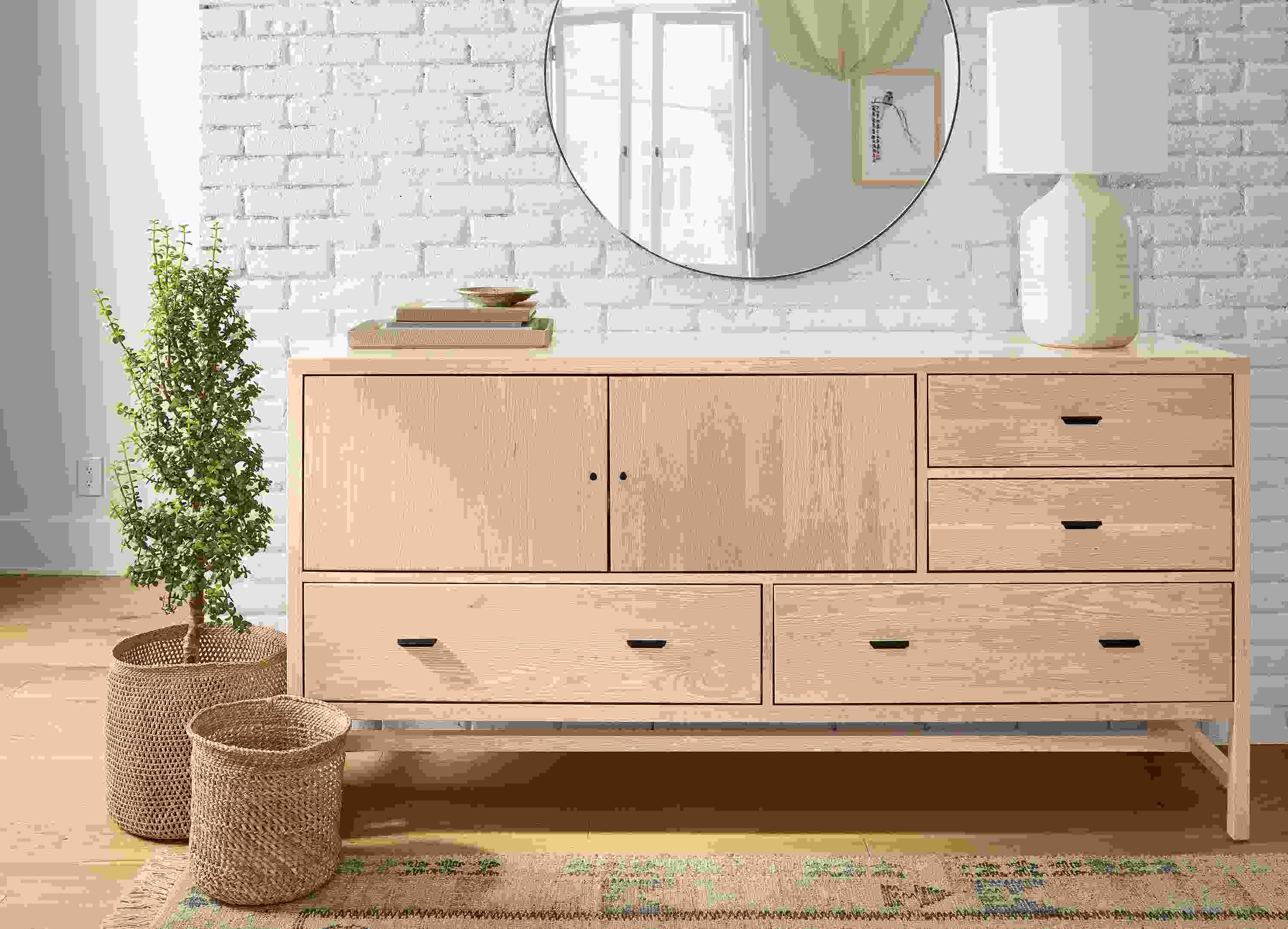 Room with detail of berkeley 72-wide storage cabinet in salt on red oak and 6 by 9 villa rug in sand.