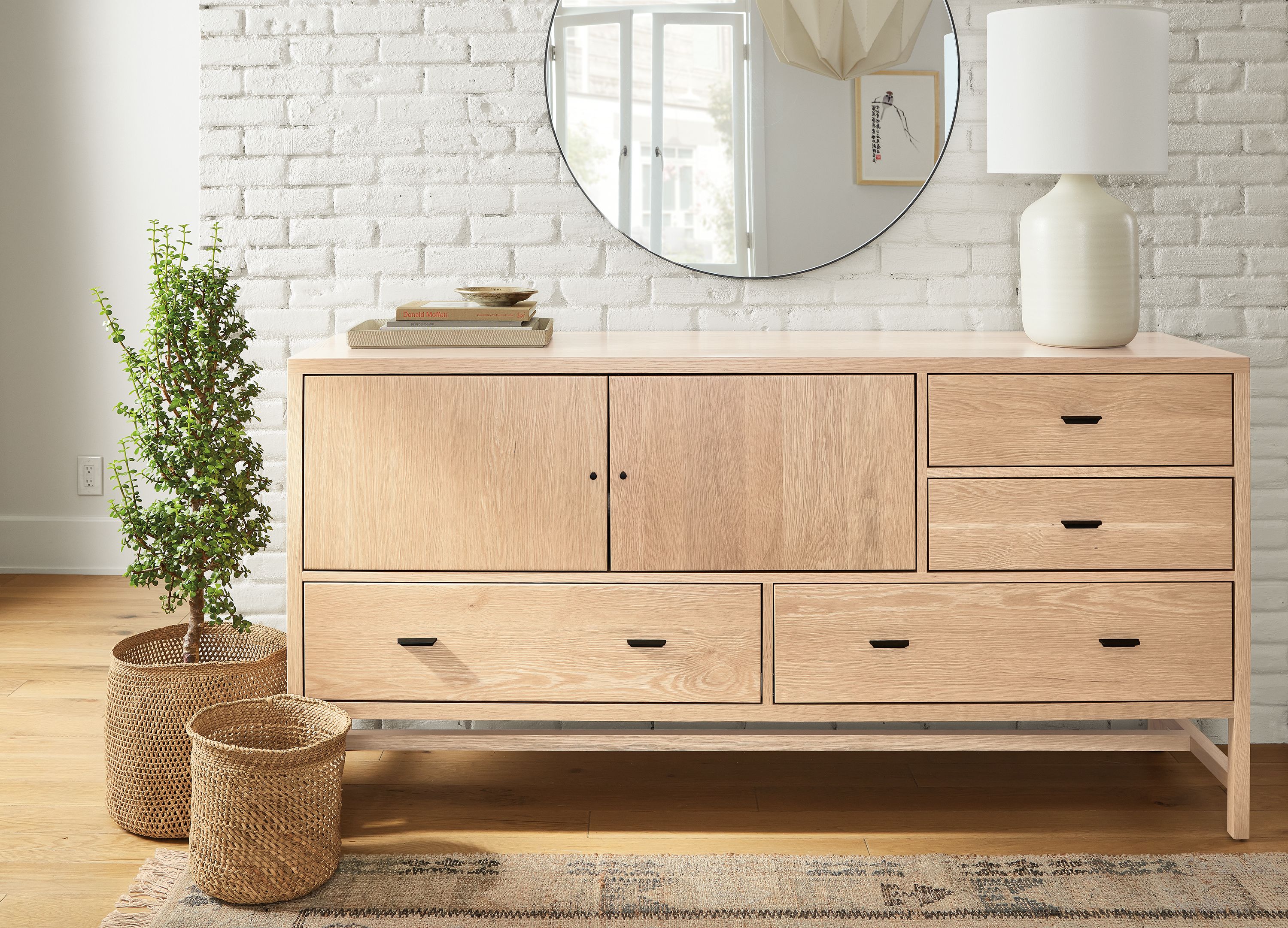 Room with detail of berkeley 72-wide storage cabinet in salt on red oak and 6 by 9 villa rug in sand.