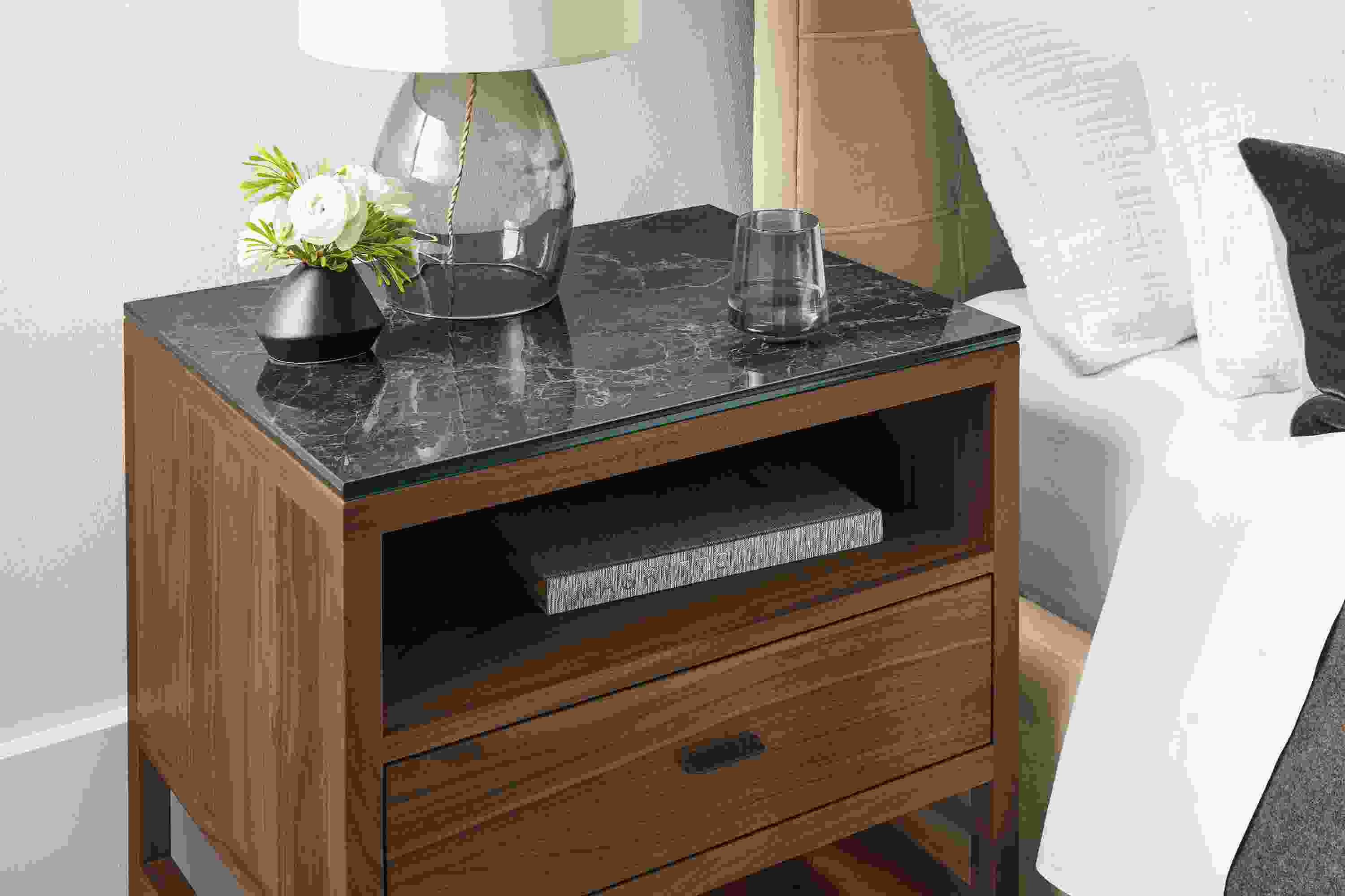 Detail of Berkeley nightstand in walnut with black marbled ceramic top in bedroom.