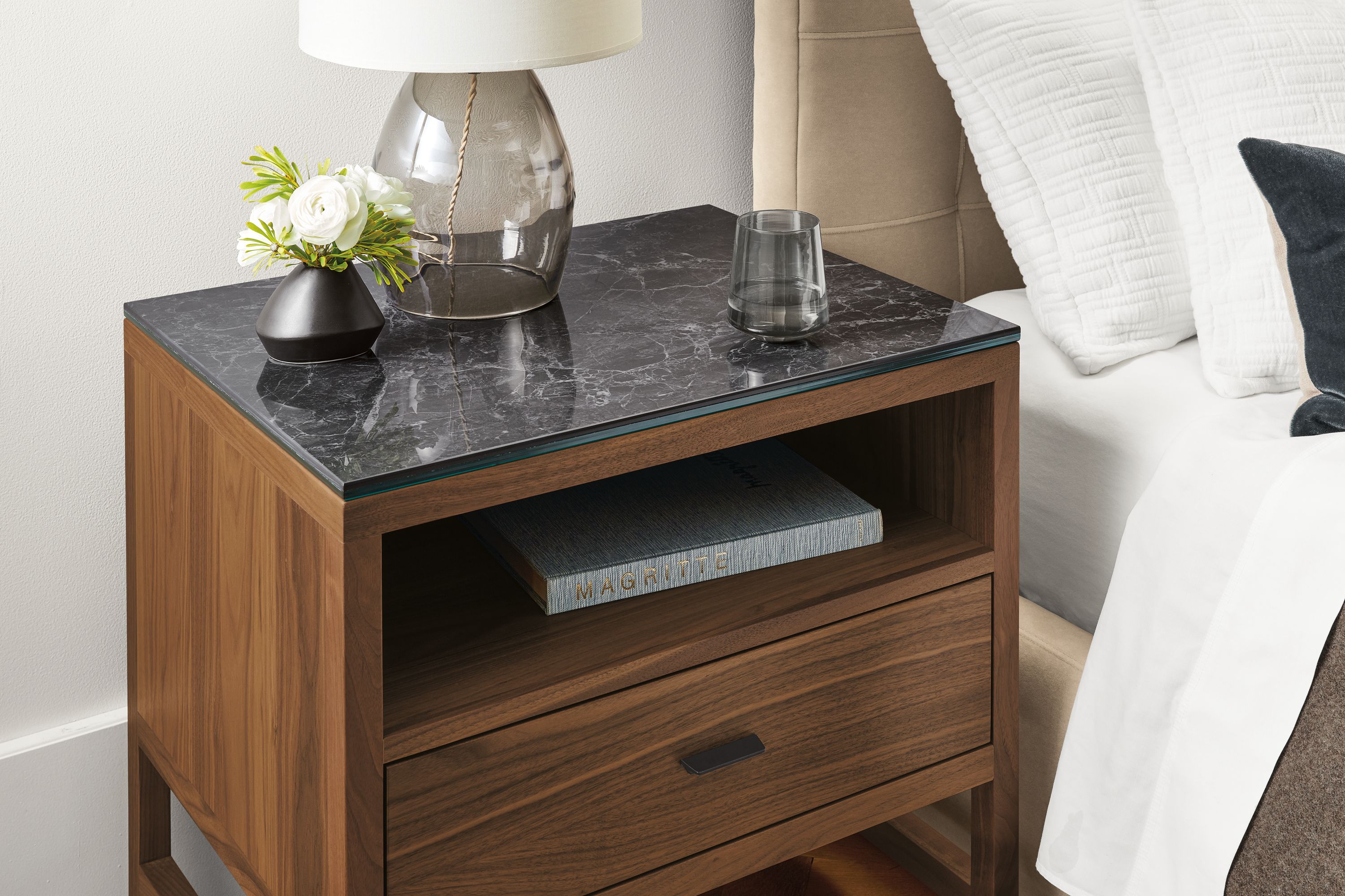 Detail of Berkeley nightstand in walnut with black marbled ceramic top in bedroom.