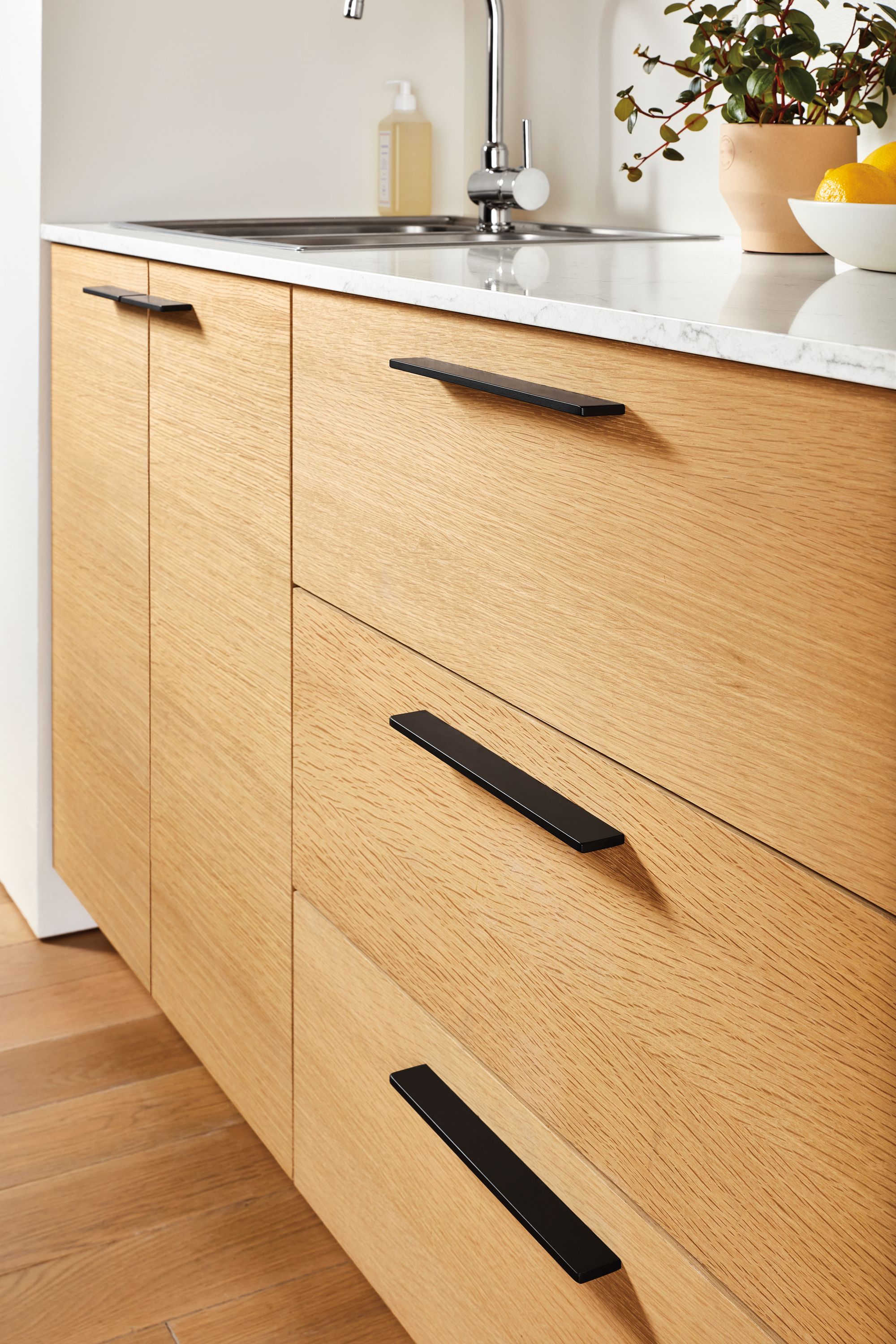 Bexley Slab Pulls in graphite: 5.25w shown on doors; 10.25w shown on drawers