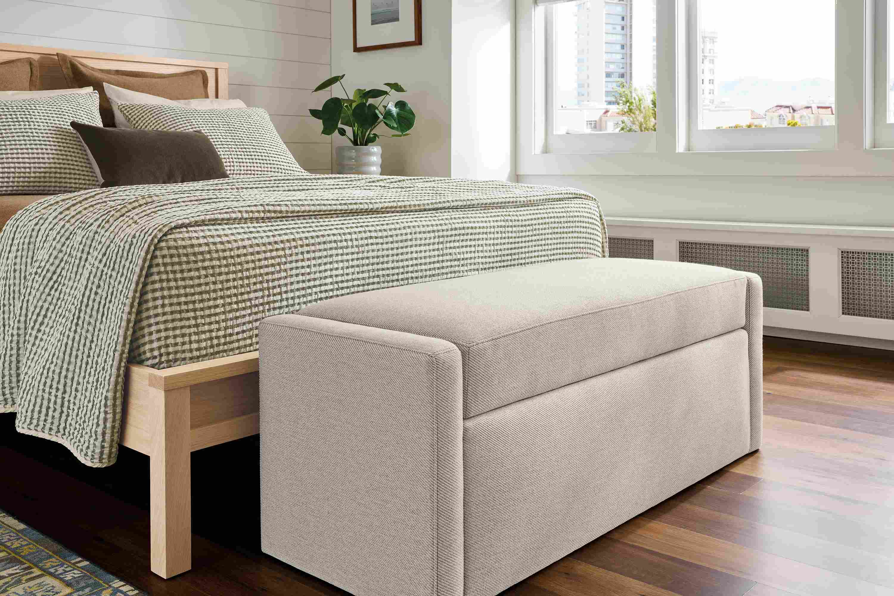 Bedroom with blakely storage bench in derry natural, emerson queen bed in salt on red oak and kayseri rug.