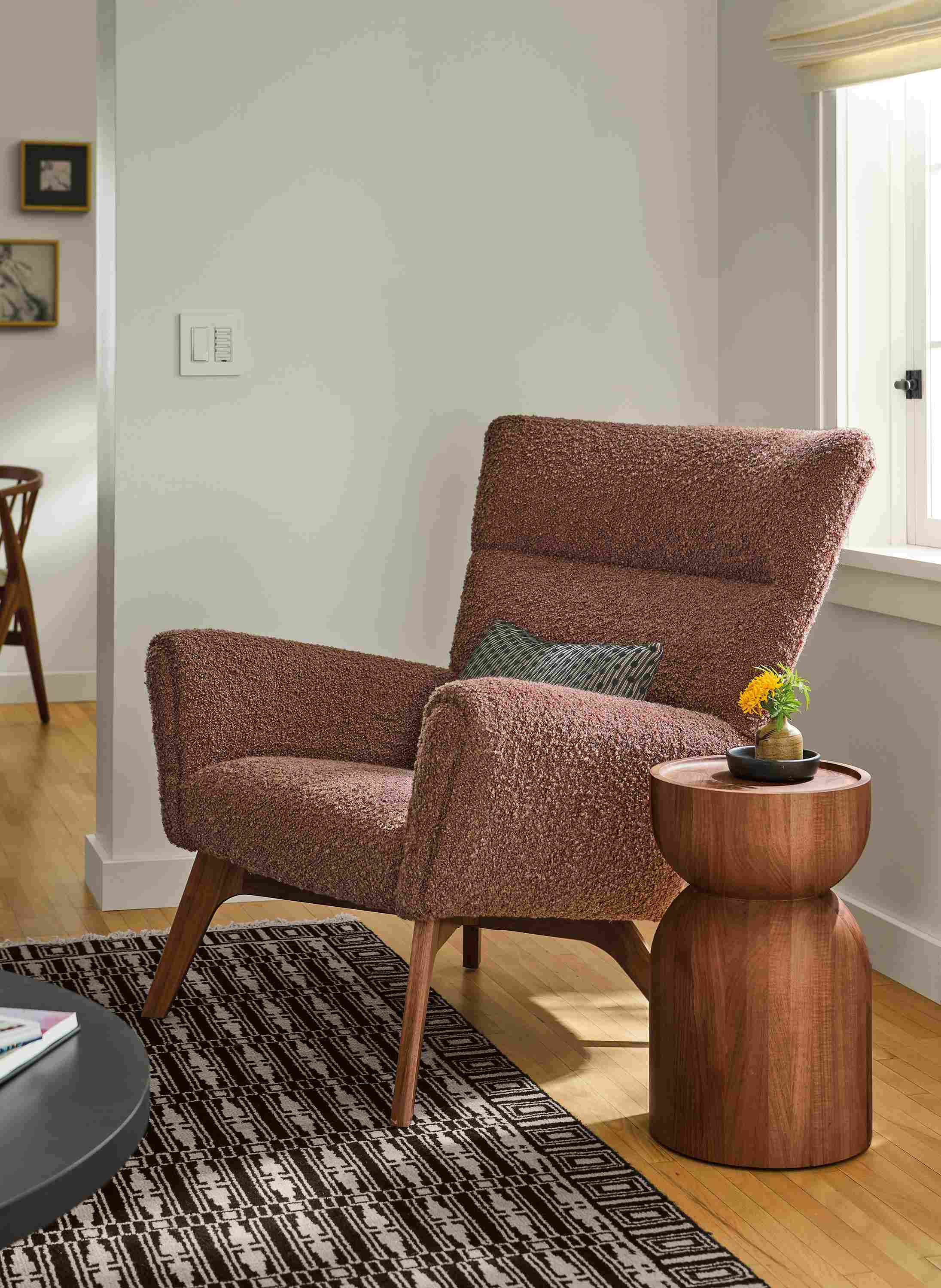 Living room with detail of Boden chair in Dornick Claystone, Macy pillow in black and Tulum Rug in Ebony.