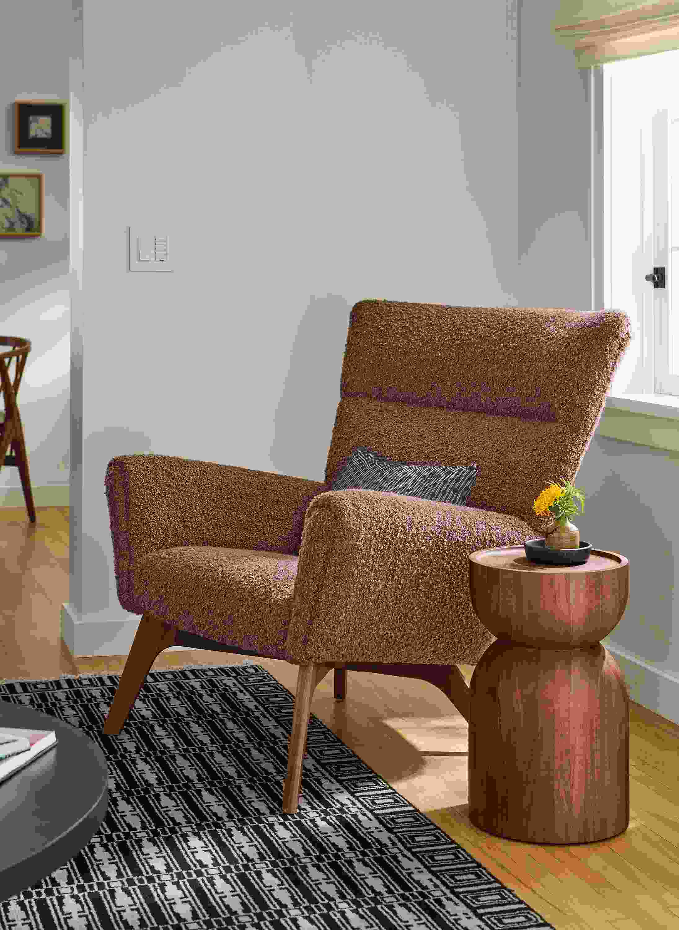 Living room with detail of Boden chair in Dornick Claystone, Macy pillow in black and Tulum Rug in Ebony.