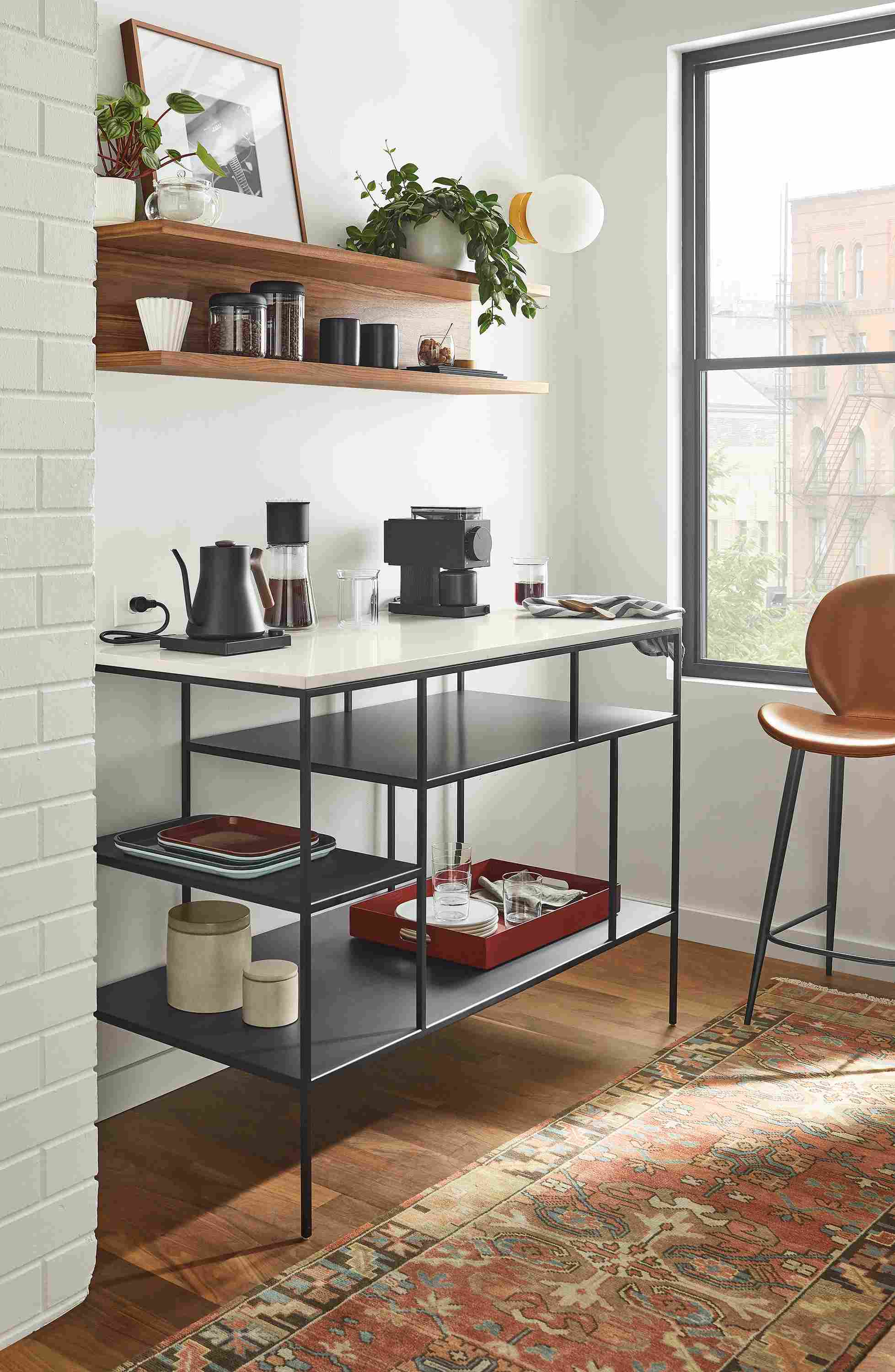 Sunny room with bowen counter table in graphite with white quartz top and gwen counter stool in brown Nola leather.