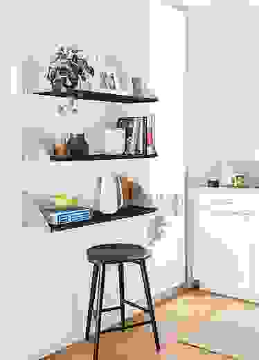 three bradley wall shelves in stainless steel holding frames, books and kitchen objects.