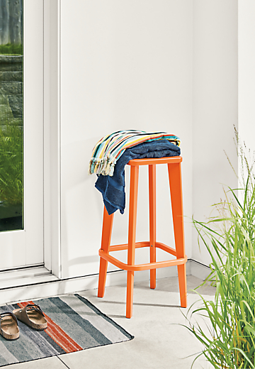 Detail of Brook bar stool in orange on patio.