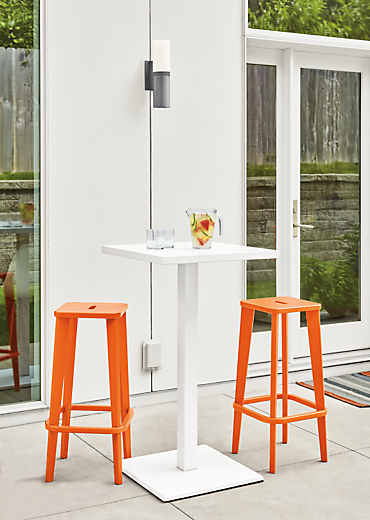 Detail of two Brook bar stools in orange on patio.