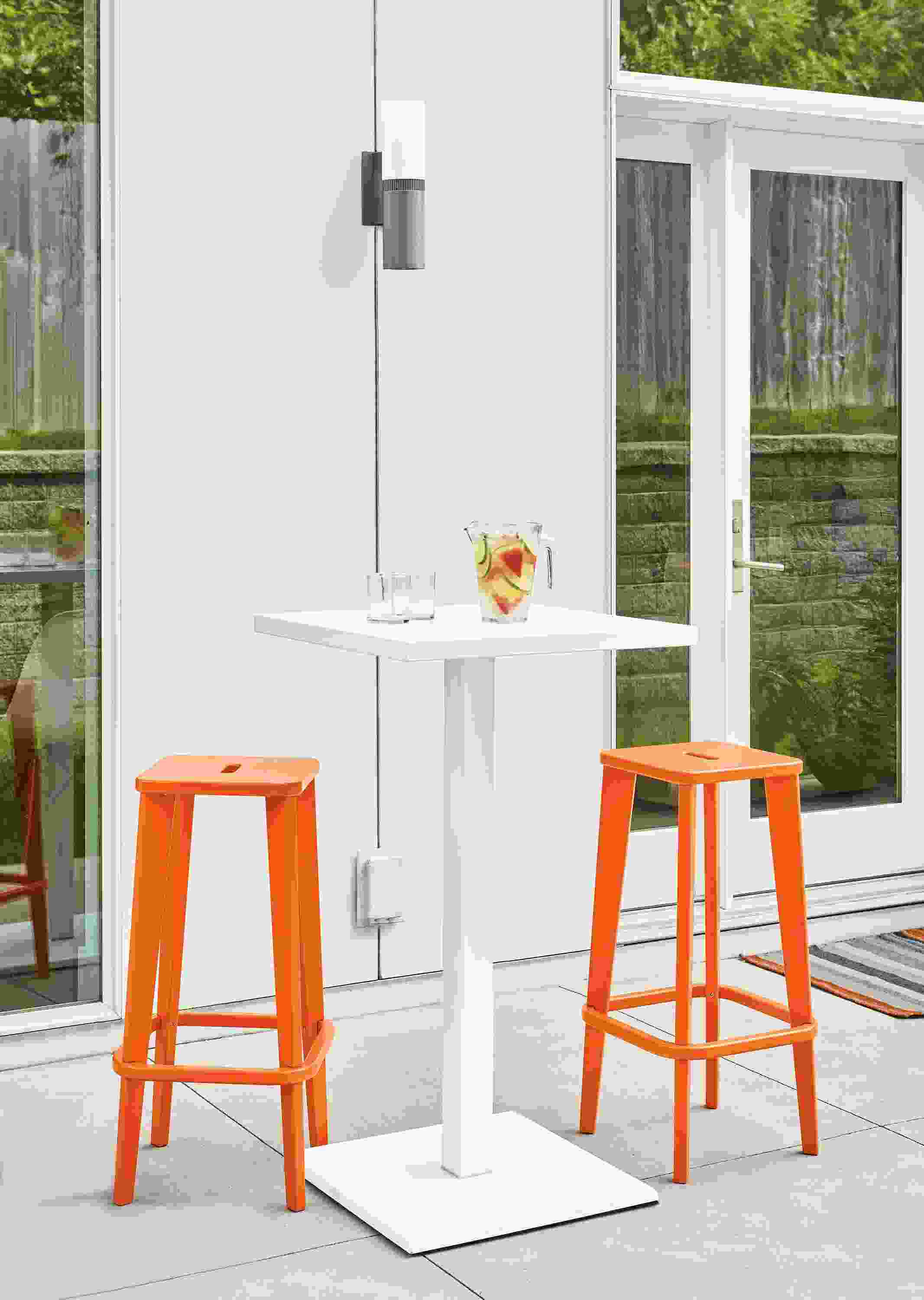 Detail of two Brook bar stools in orange on patio.