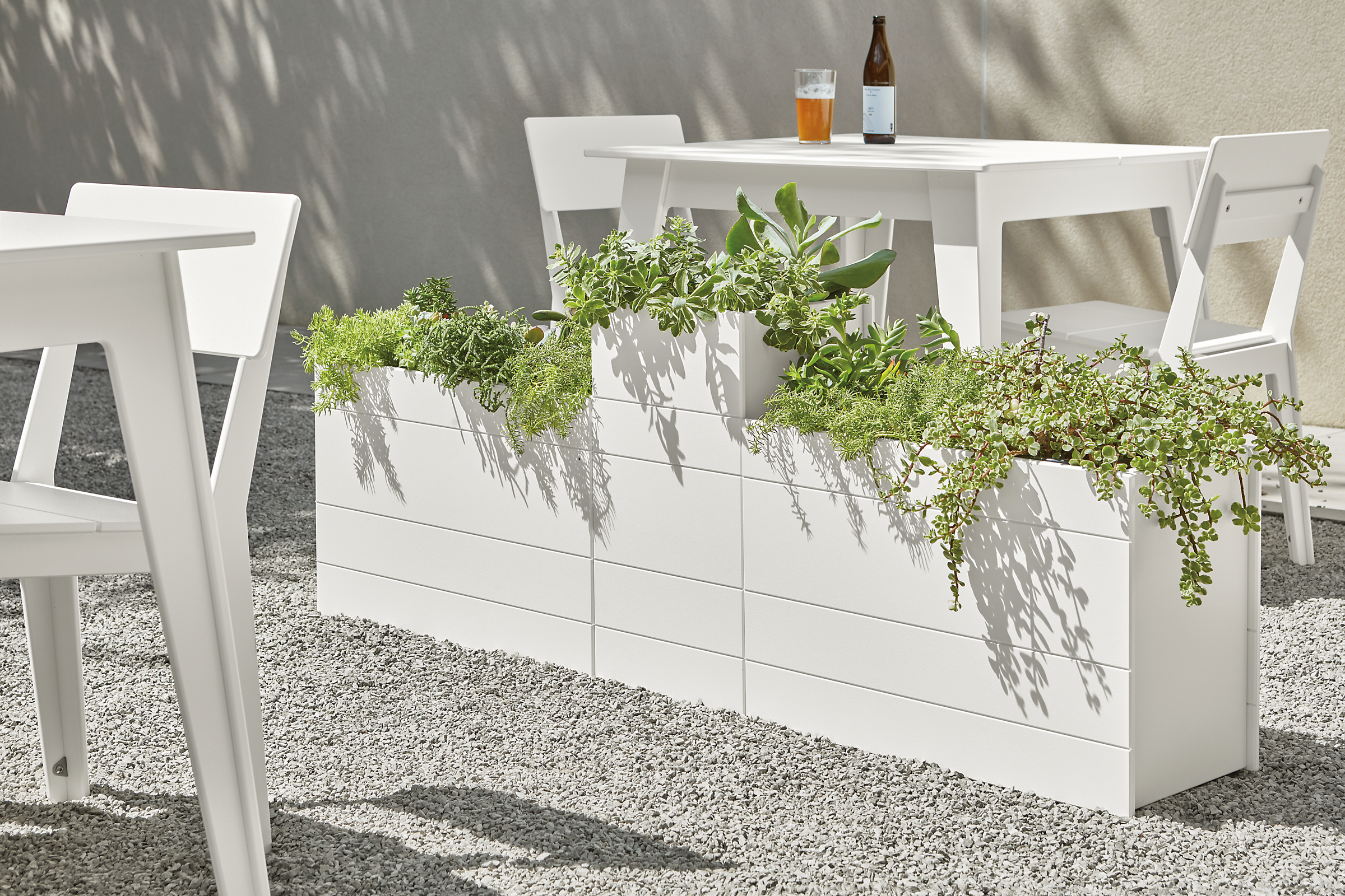 Three Brooklyn planters and Aspen outdoor table and chairs in white.