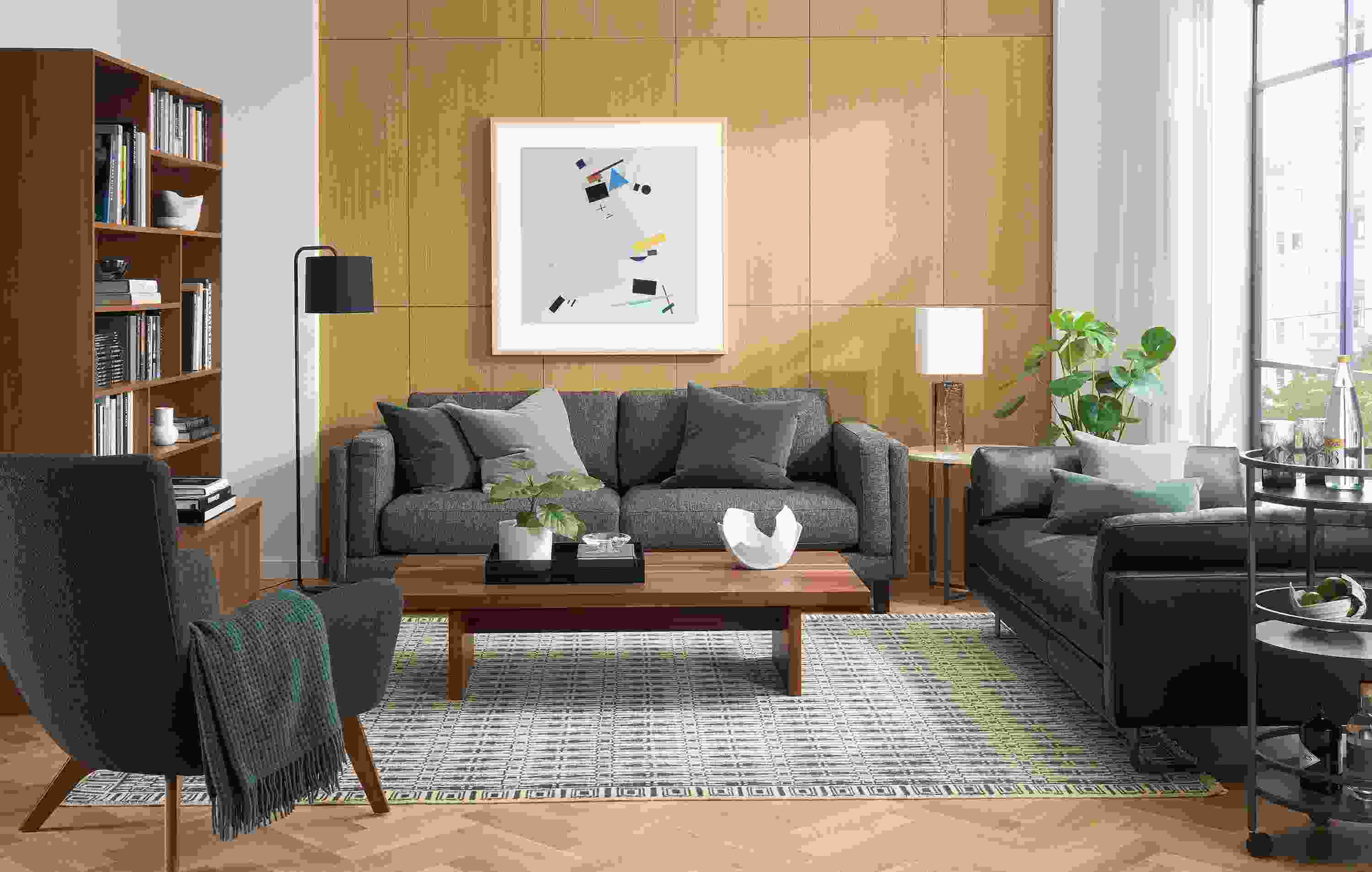 Living room with cade 91-wide sofa in tepic charcoal, pierson daybed in laino black leather and tulum rug in slate.
