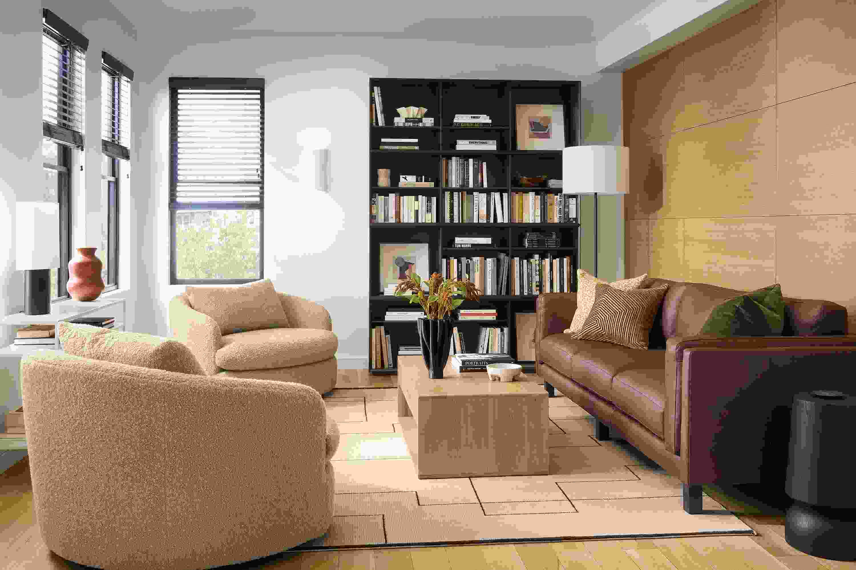 Living room with cade 3-cushion sofa in laino cognac leather, suri swivel chair in dornic camel and graft coffee table.