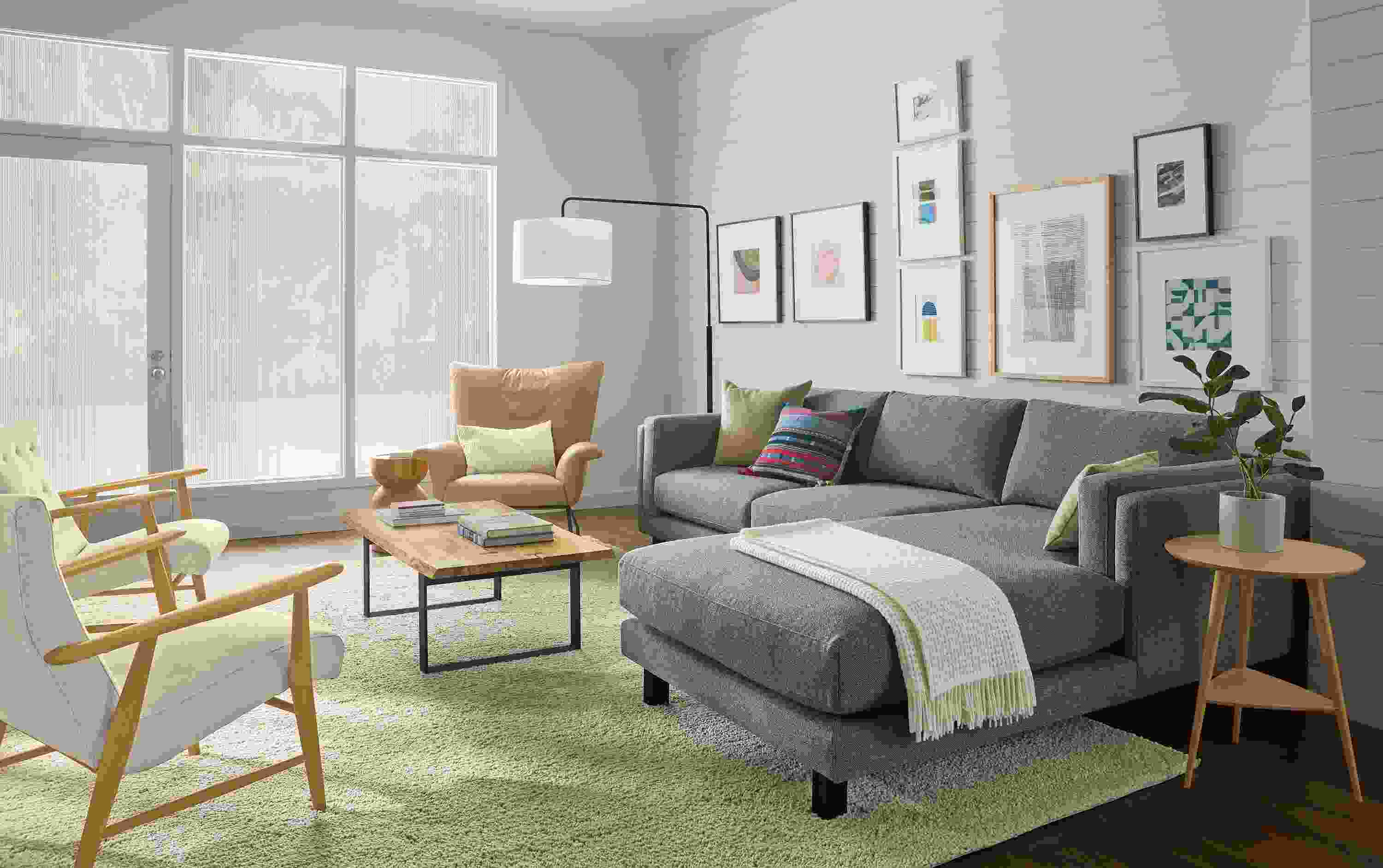 Living room with cade 114-wide sofa with right-arm chaise in tatum slate, paris chair in fiero camel leather and Arden rug in oatmeal.