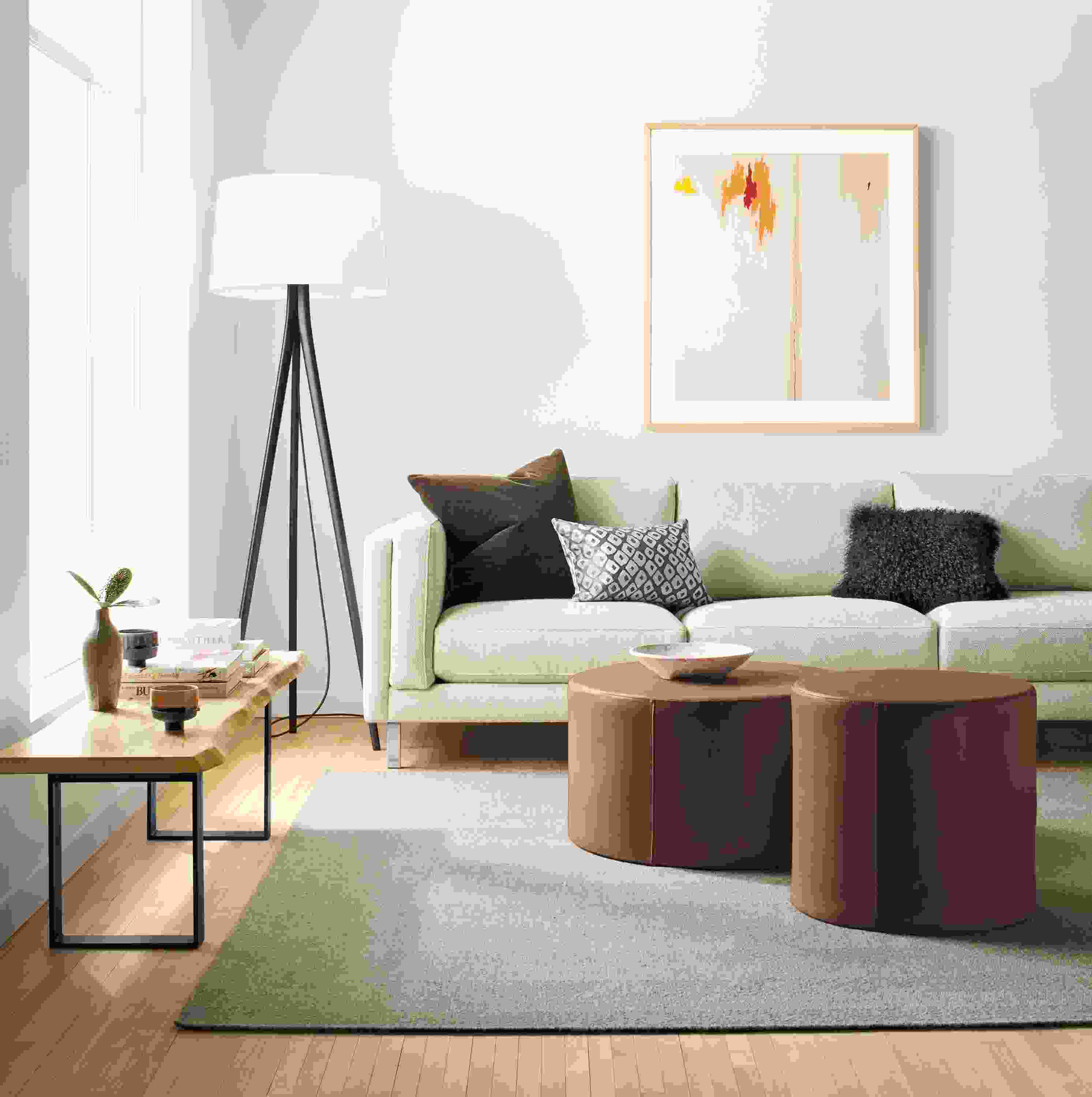 Living room with Cade sofa in orla ivory, 2 aero round ottomans in laino cognac leather and avilia rug in taupe.