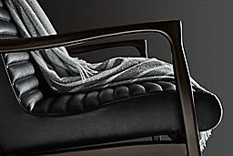 close-up of callan chair with charcoal arms and black leather upholstery.