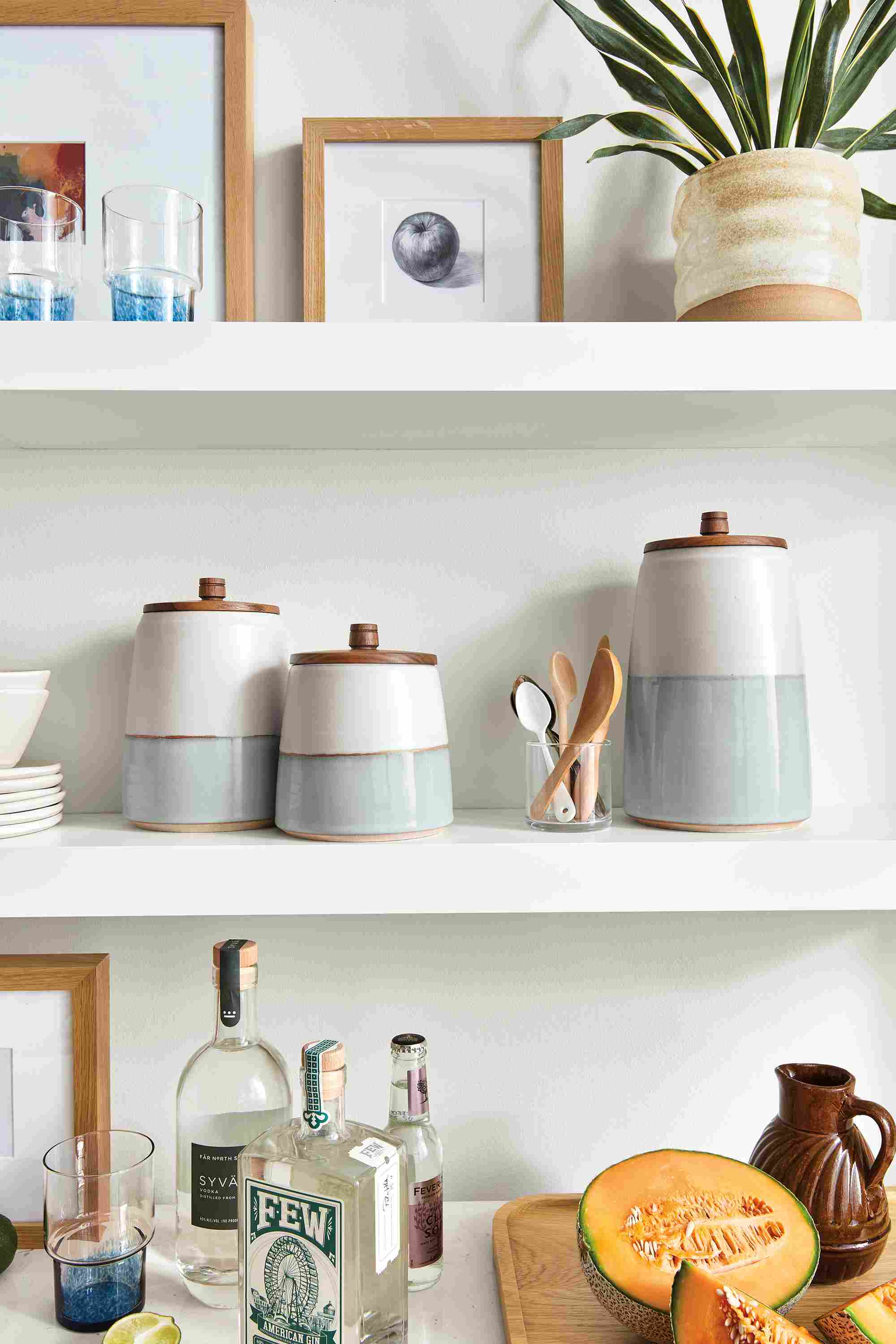 Kitchen shelving with Calument storage canisters and ivory/sky, profile frames in white oak and elias planter in natural.