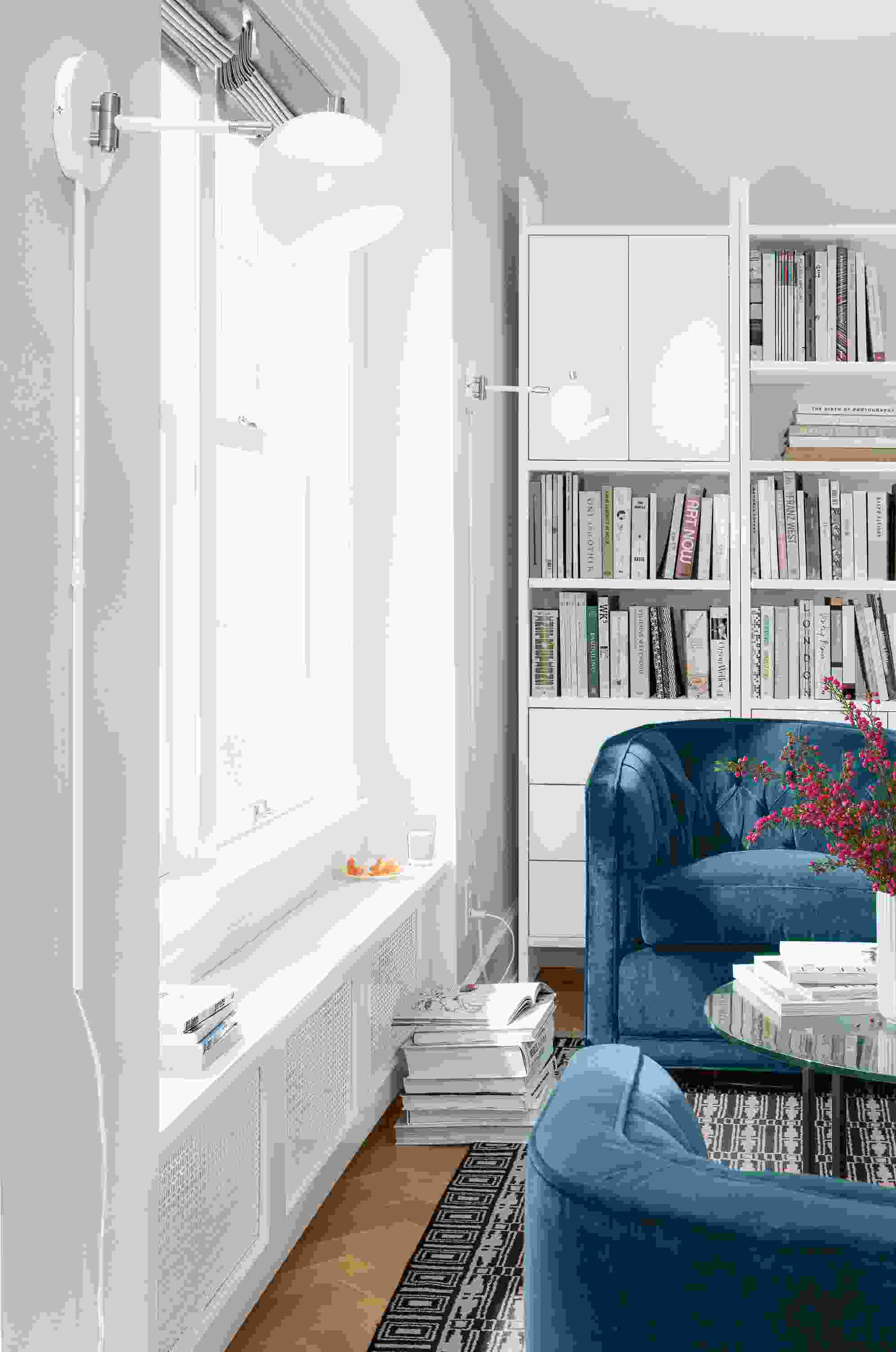 Detail view of white Camber wall sconce in white living room.