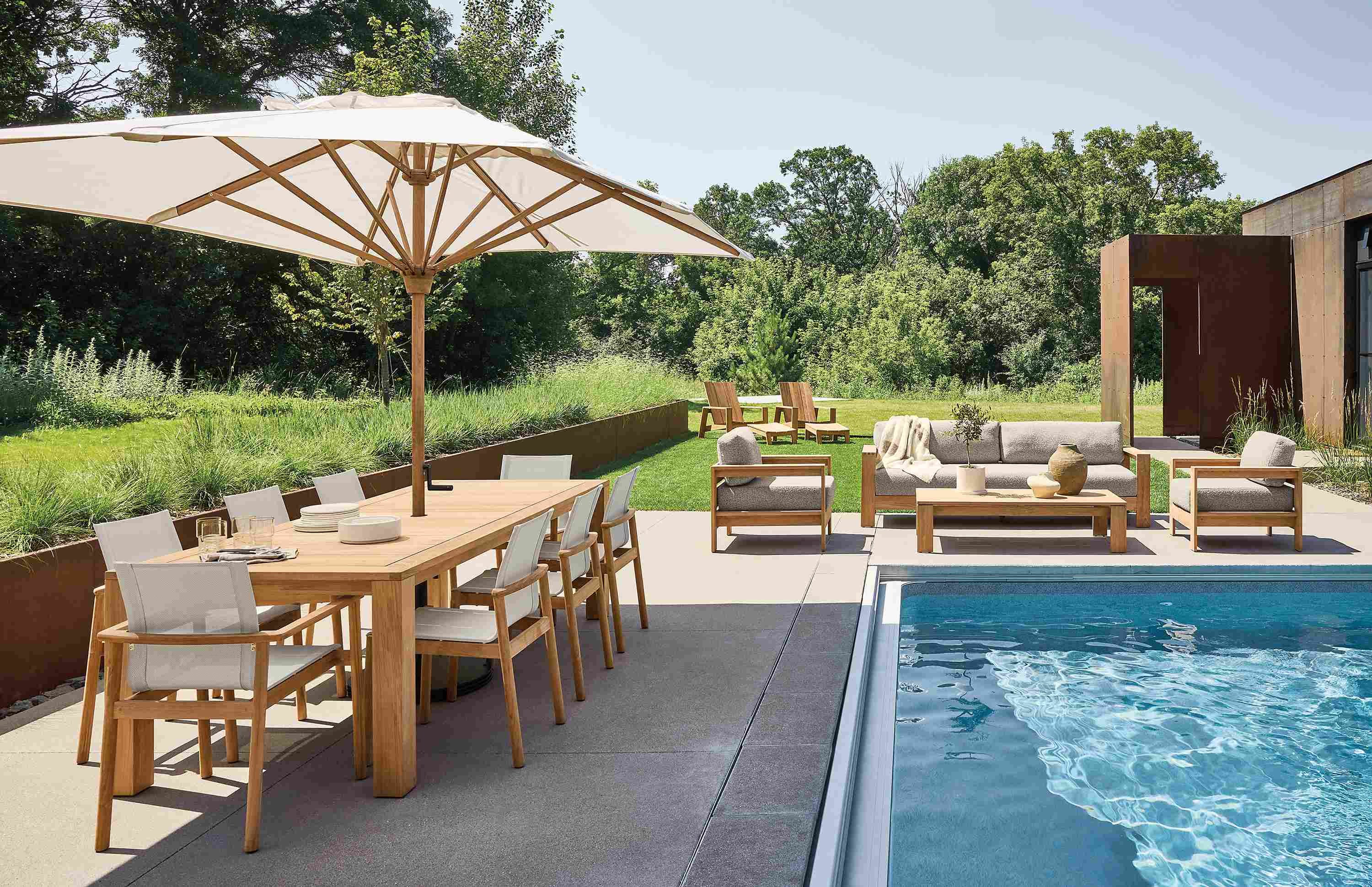 Pool area with Capri table, 2 Peri arm chairs and 6 Peri Side chairs in teak heartwood.