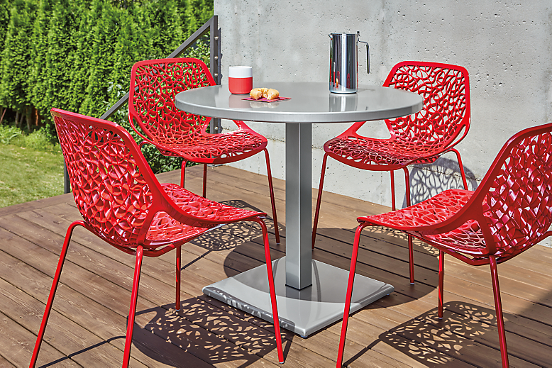 Detail of red Caprice outdoor dining chairs on patio.