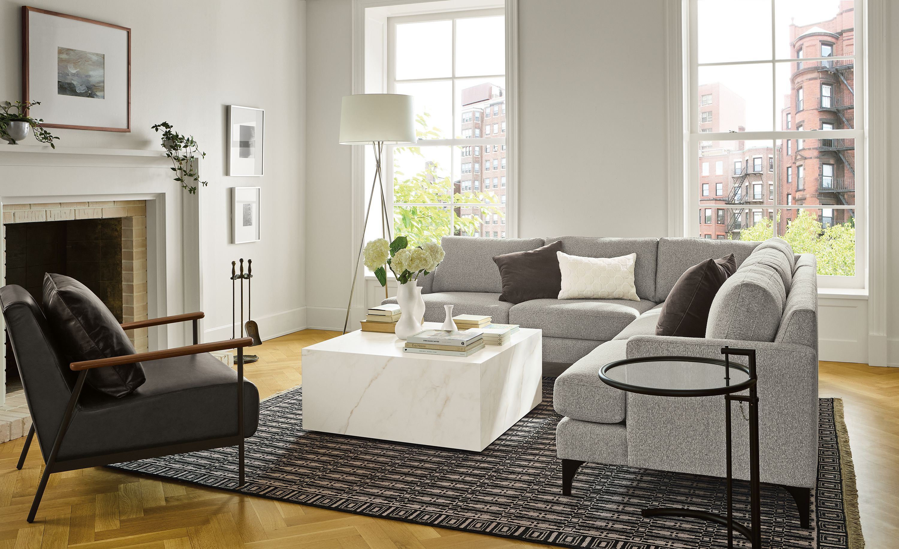 Living room with Carlton 101 by 101 sectional sofa in Conley Grey and Xavier chair in Palermo Charcoal leather.