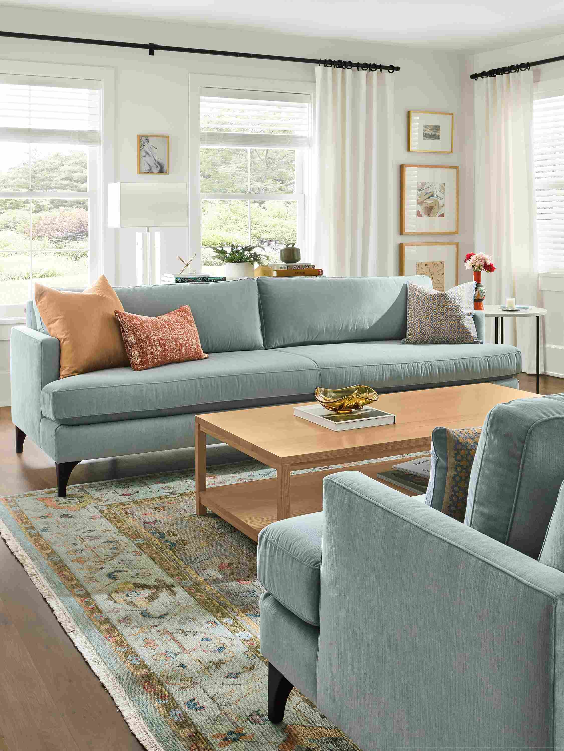 Living room with 2 carlton bench-cushion sofas in windsor cloud, clark coffee table in rye on red oak and sundar rug in sky.