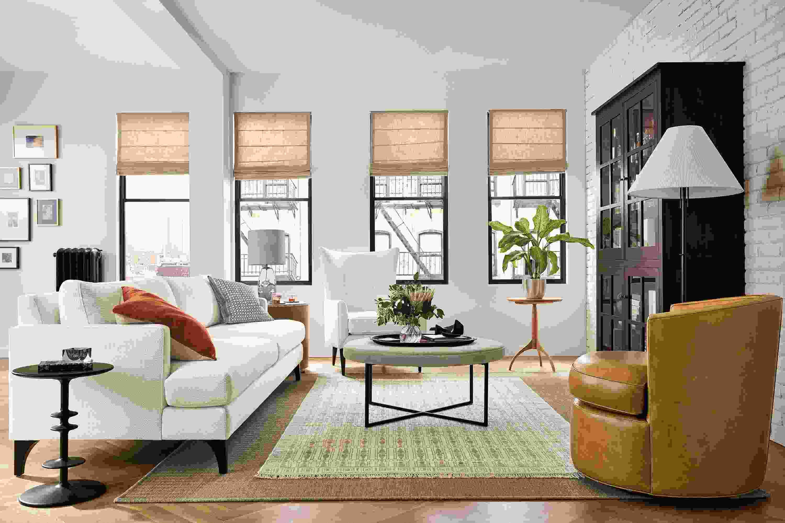 living room with carlton sofa in orla white fabric, brandford chair in white, otis swivel in leather and sidney ottoman.