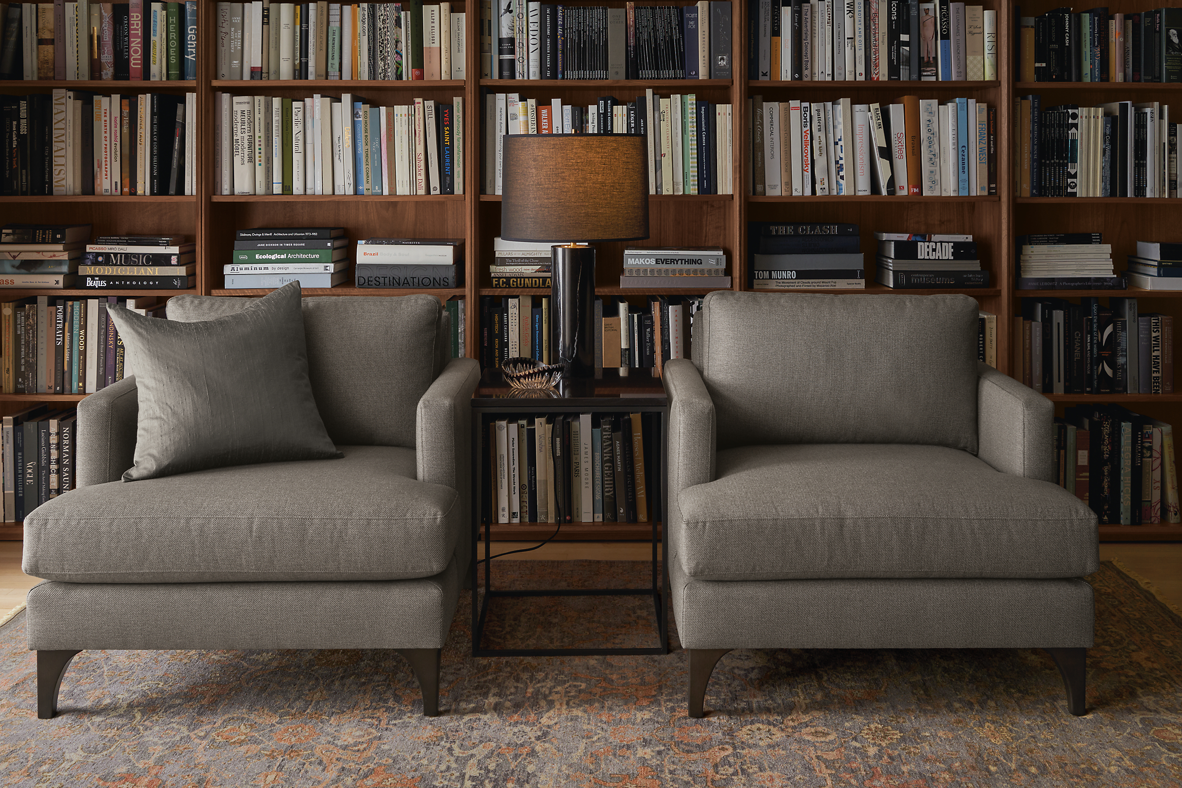 Living room library with a pair of Carlton chairs in Gino Coal fabric and Vesuvio rug in Grey/Charcoal.