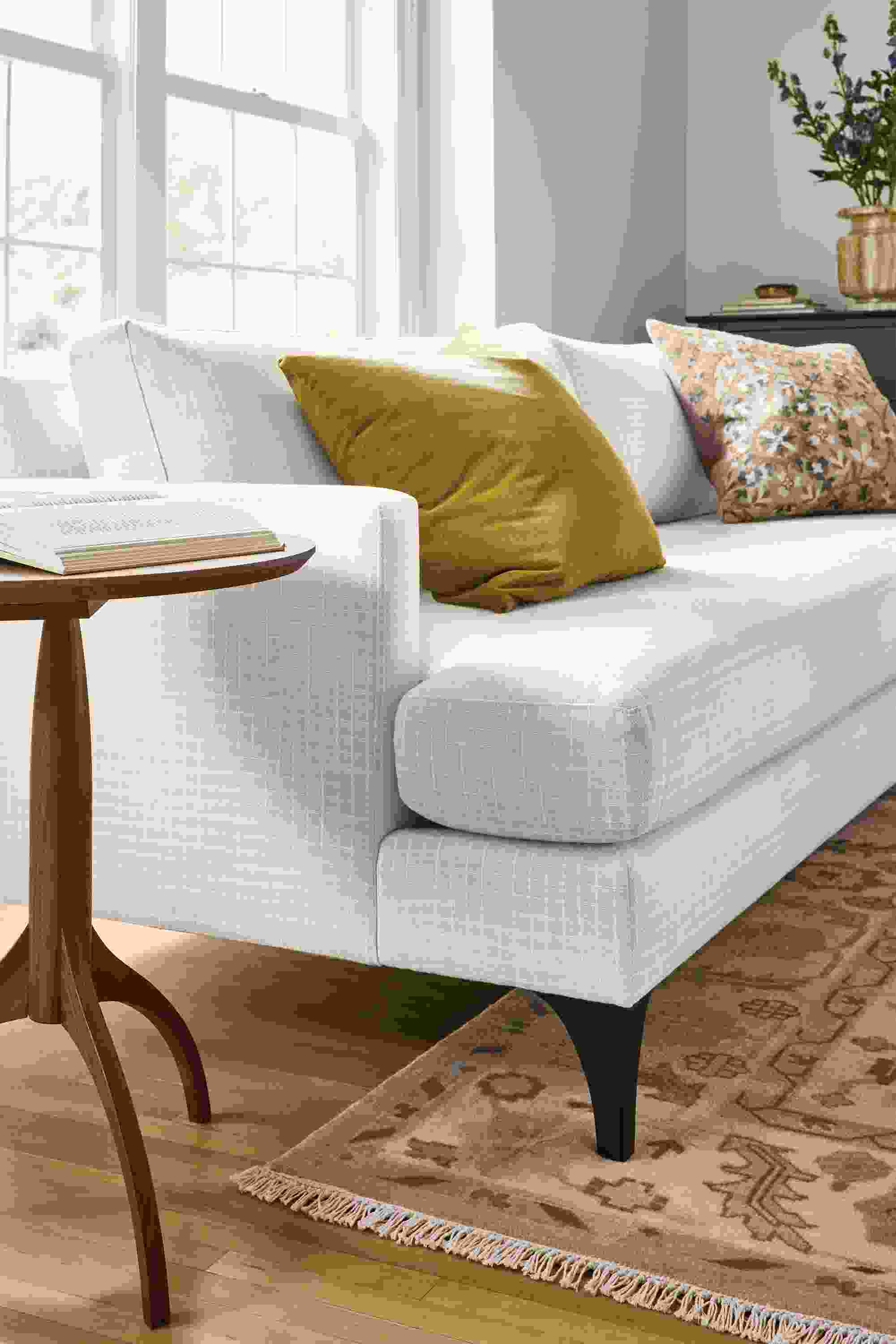 Living room with detail of Carlton 96-wide sofa in Prado Natural and Adams round end table in walnut.