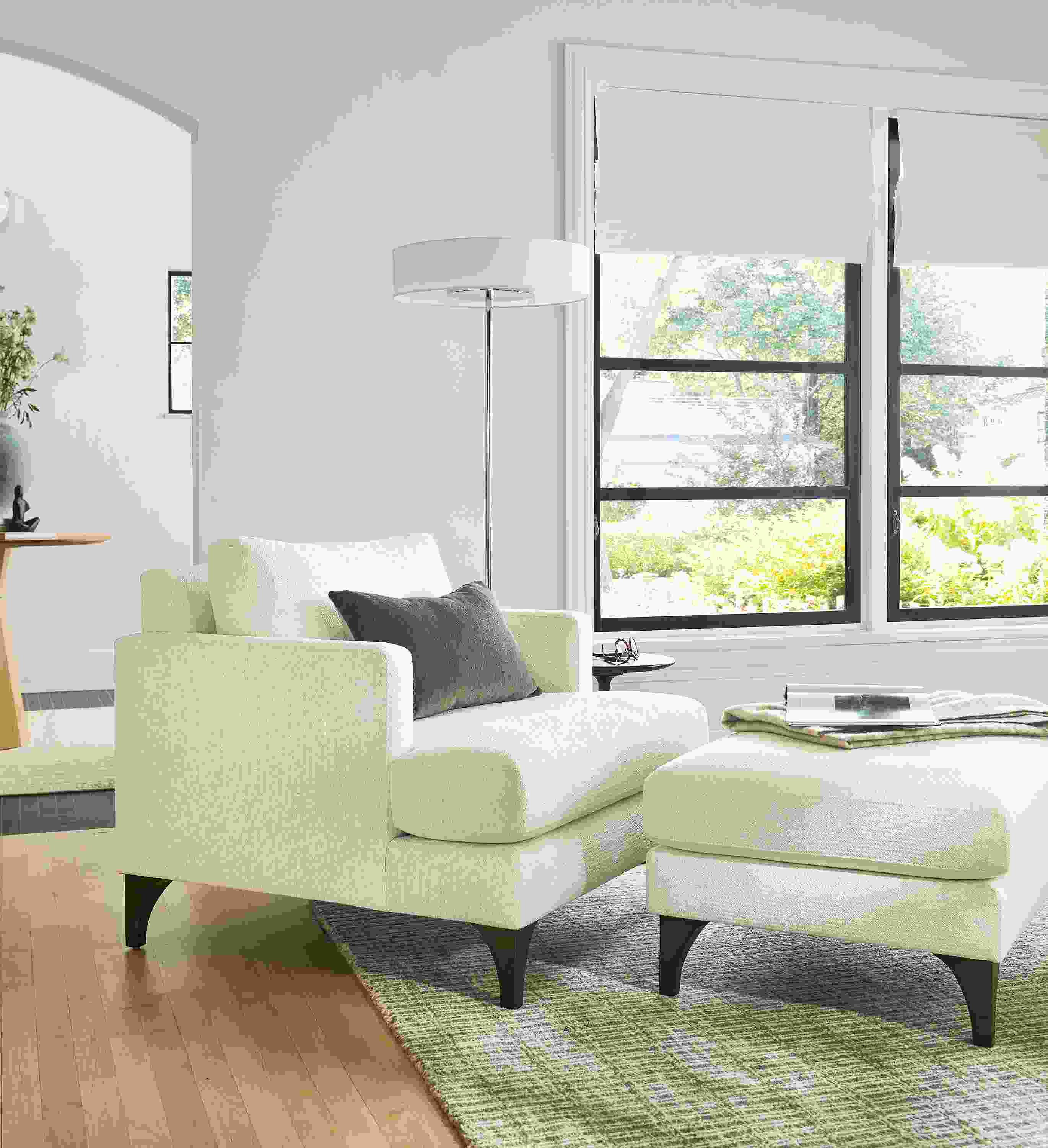 Living room with Carlton chair and ottoman in Orla White, Cohen floor lamp in polished nickel and Nera 8 by 10 rug in stone.