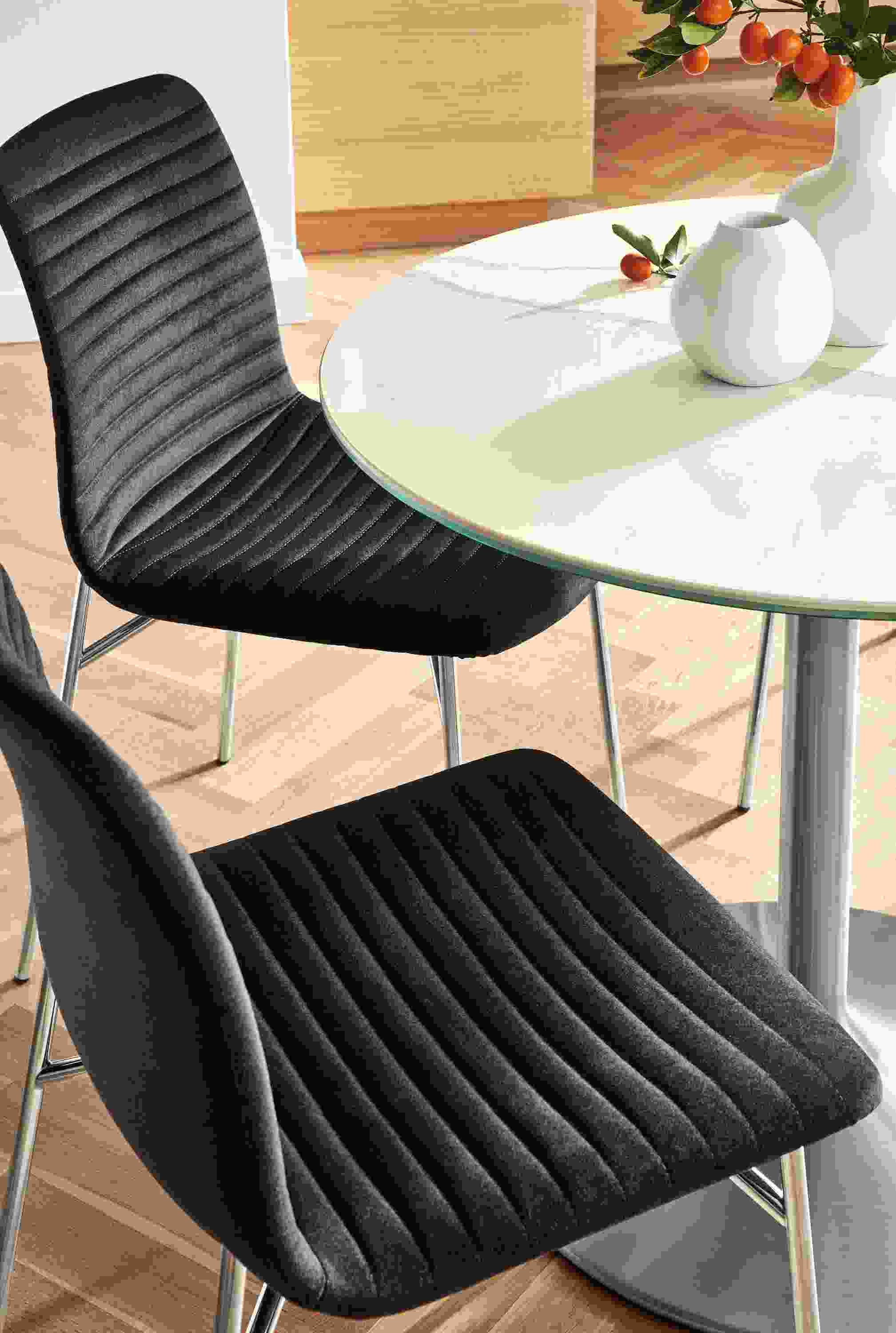 Two Cato side chairs in fabric and stainless steel Aria table.