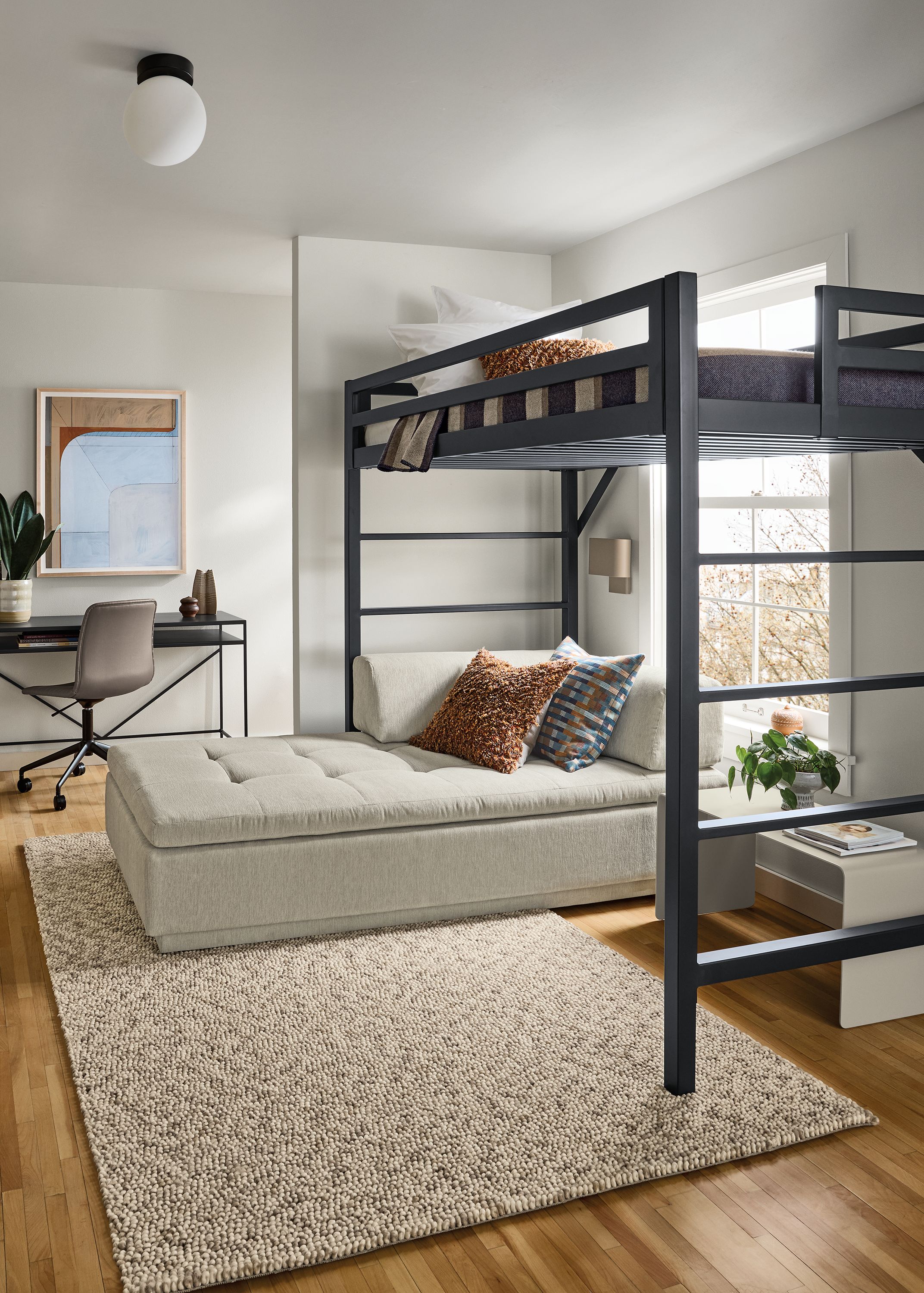 Room with a Chase twin loft bed and slim desk in natural steel, Cato office chair in Sarno Putty leather and Hastings rug in ivory/taupe.