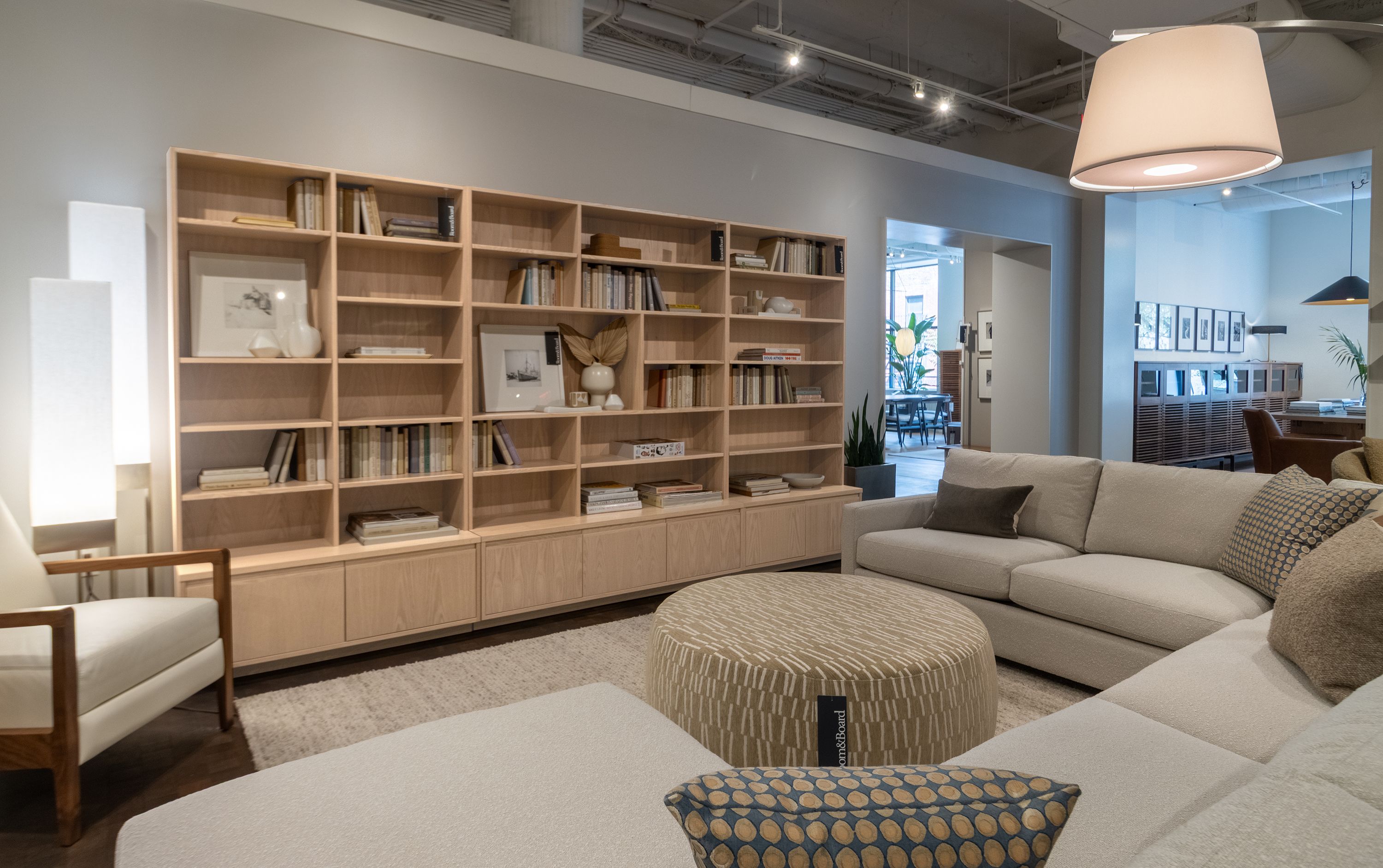 Store image with 3 Keaton bookcases in salt on red oak, Linger sectional sofa in Declan Natural.