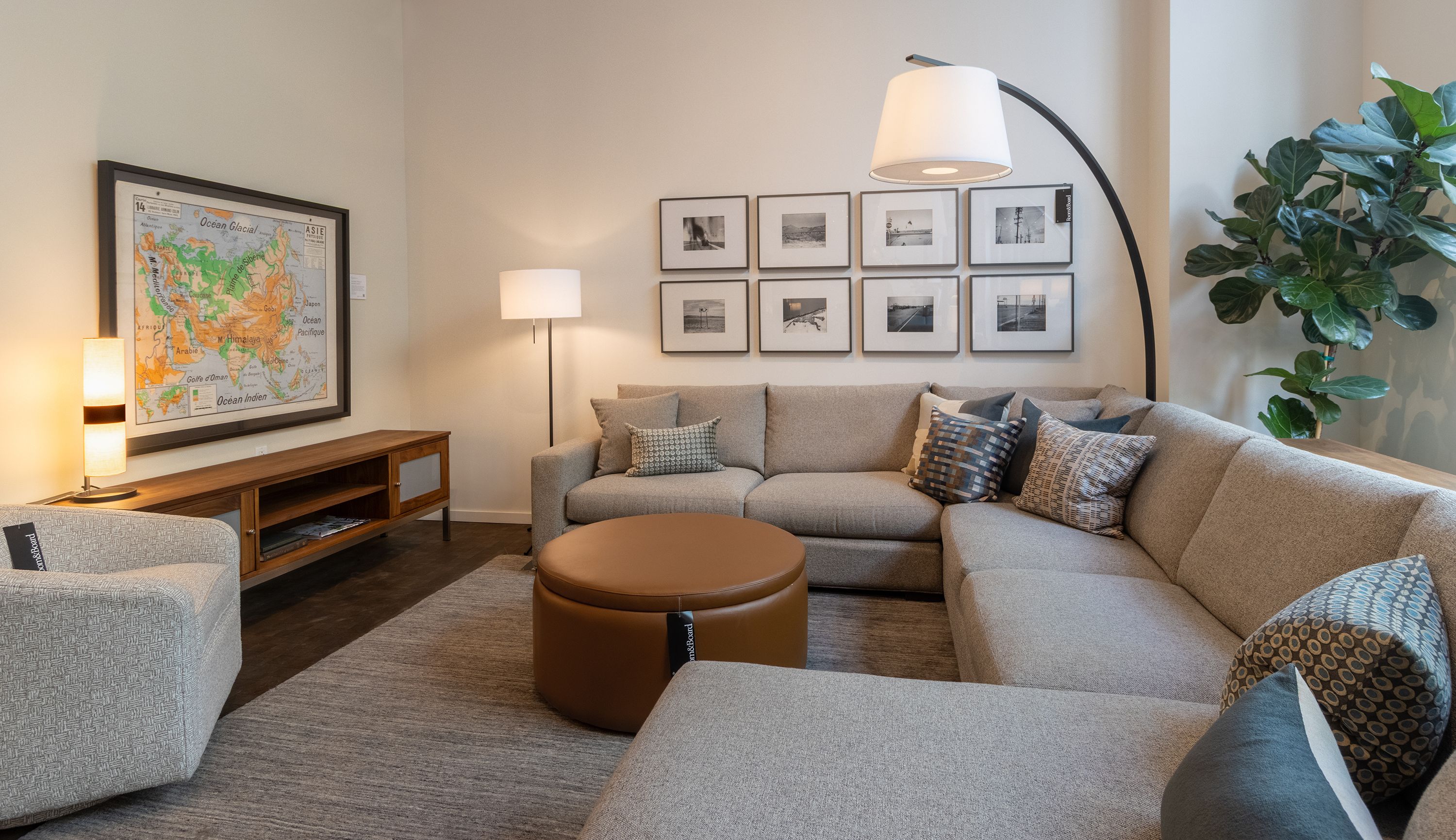 Store image with Metro sectional sofa in Tatum Grey, Lind ottoman in Pesaro Cognac and Nomad rug in charcoal.