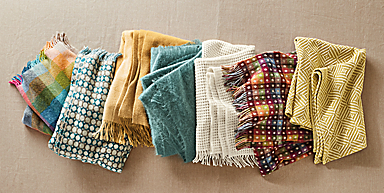 folded colorful throw blankets arranged in line