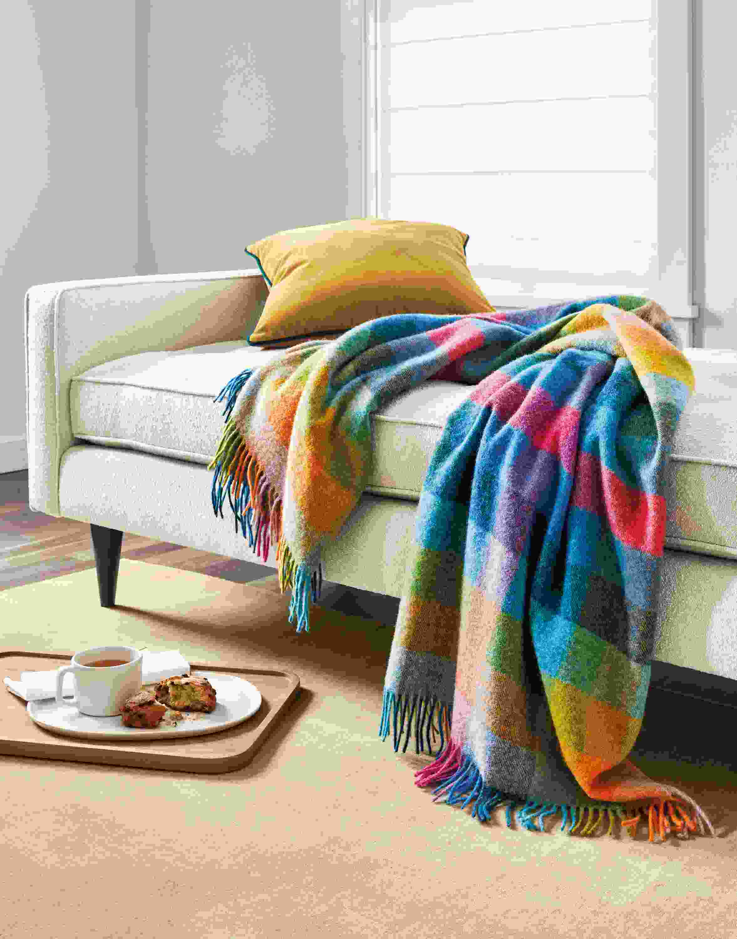 Detail of colorful Clare throw blanket, Reese daybed and Felix pillow in mustard.